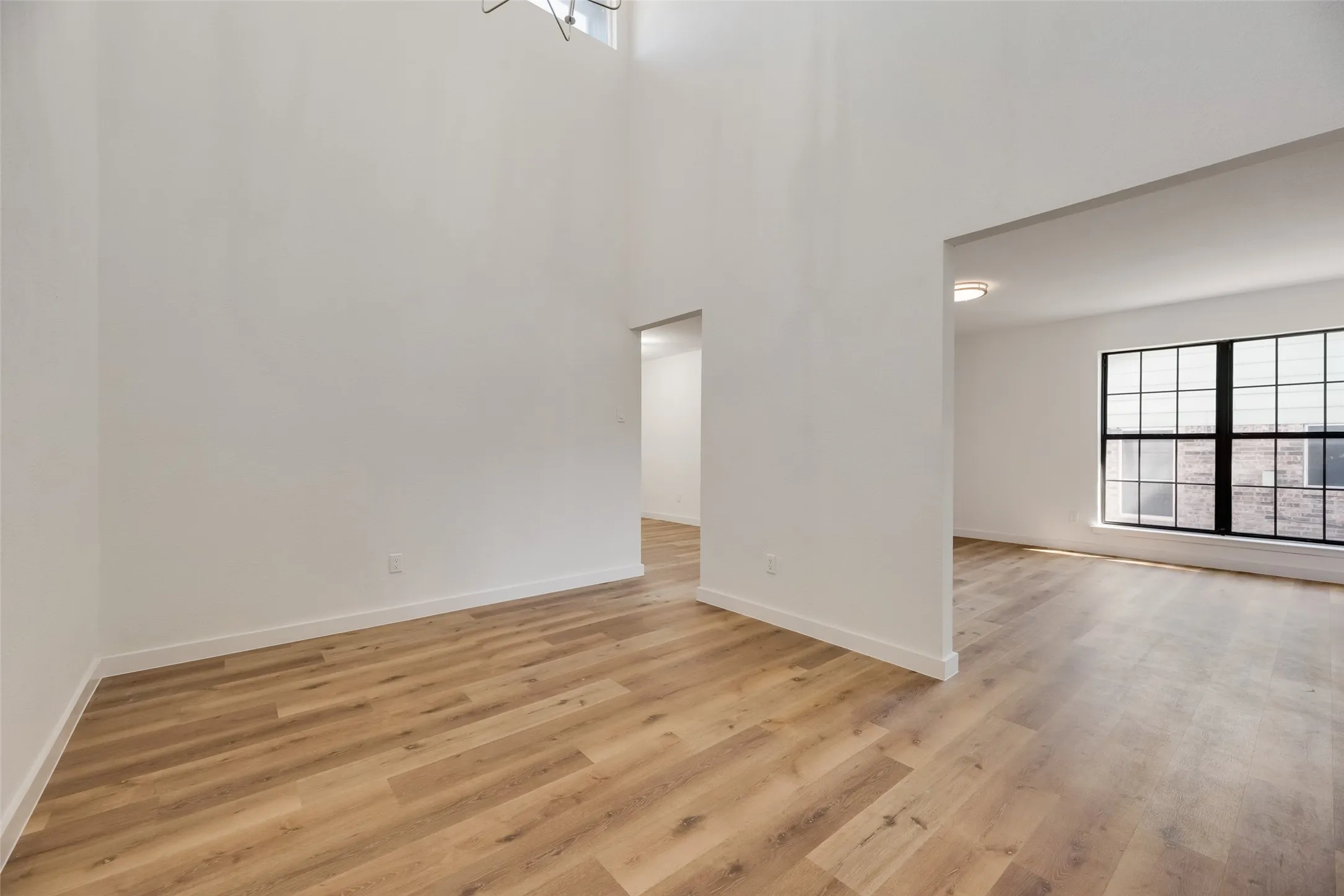Soaring ceilings accentuate the open-concept design and wood-finish flooring