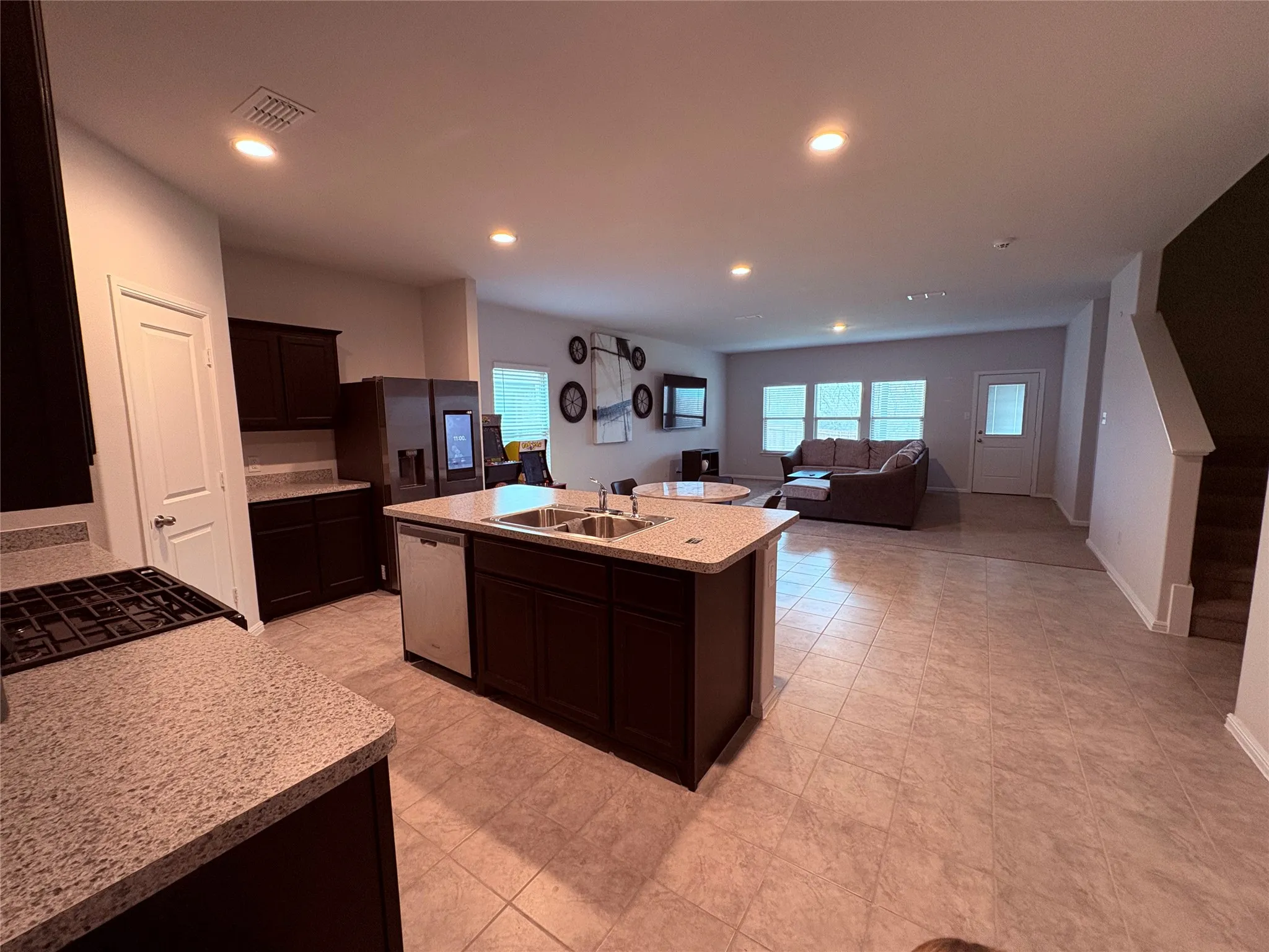 Open-concept living area with tile flooring and recessed lighting