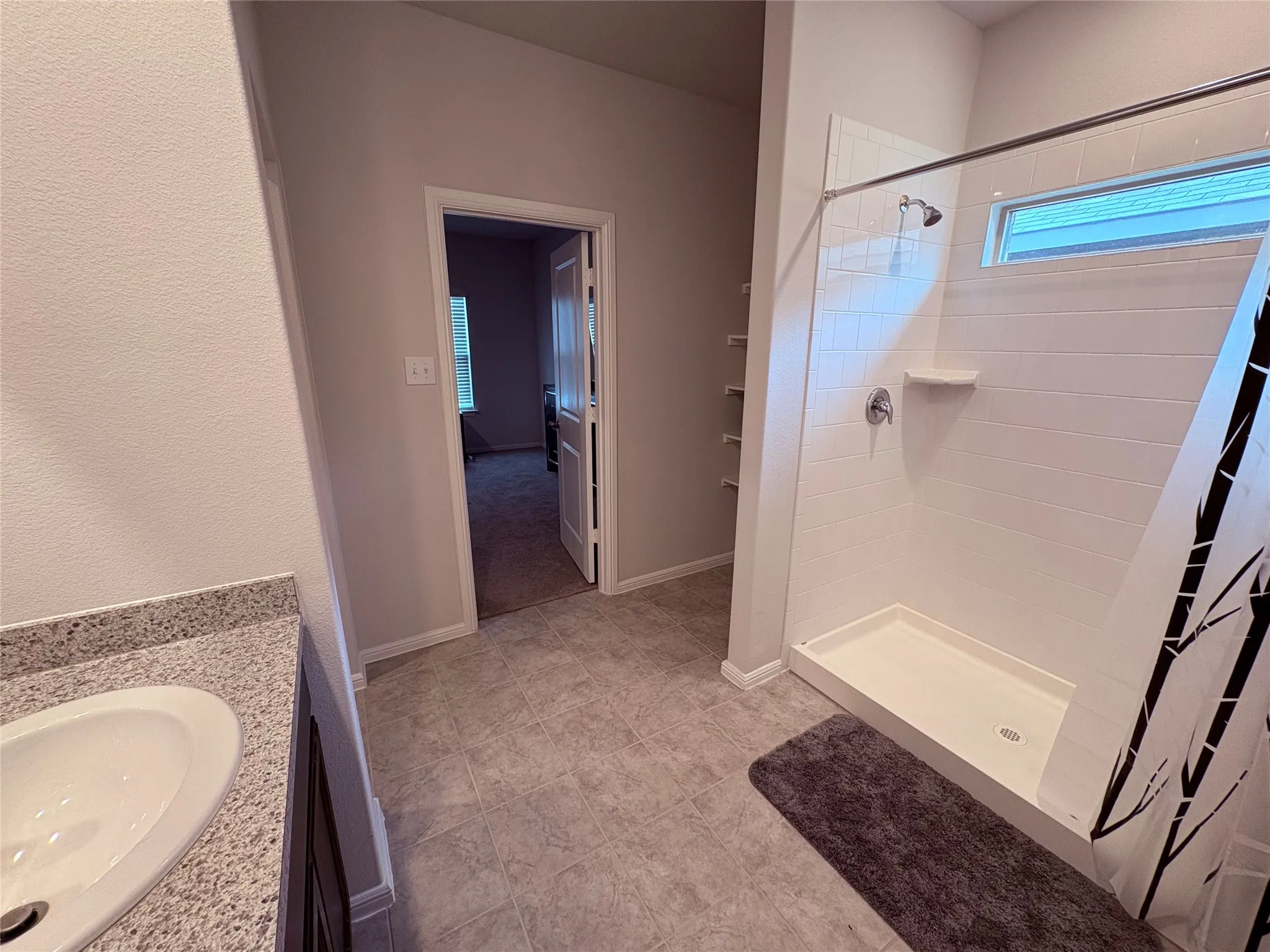 White subway tile shower surround with a built-in shelf and transom window