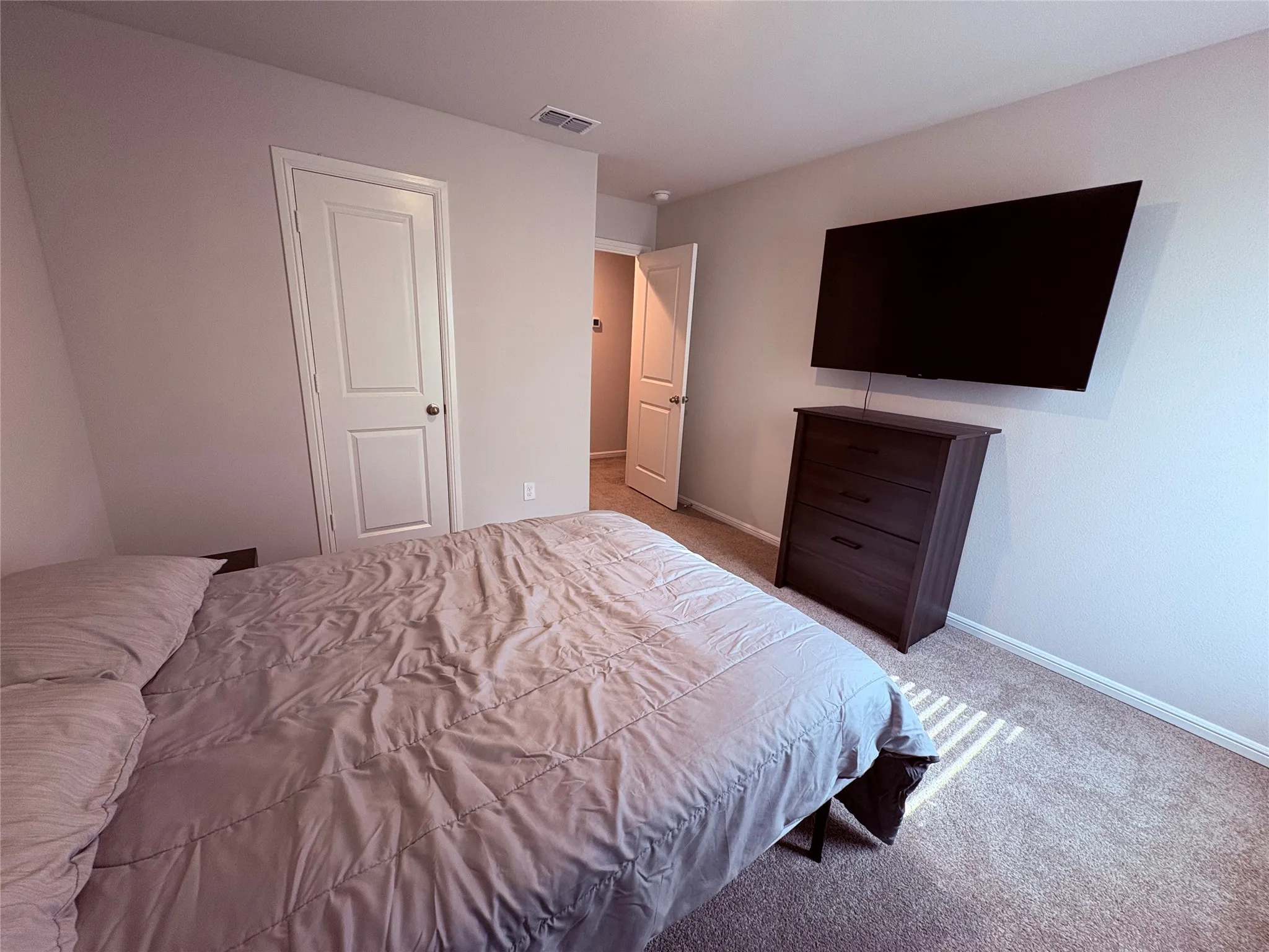Neutral wall paint, white trim, and carpeted flooring
