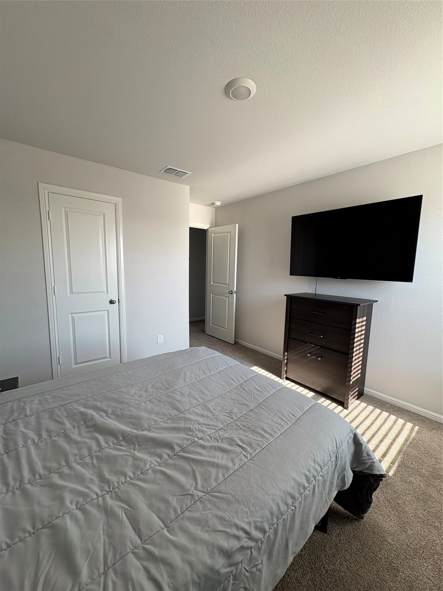Recessed ceiling lighting, white interior doors with round hardware, and carpet flooring
