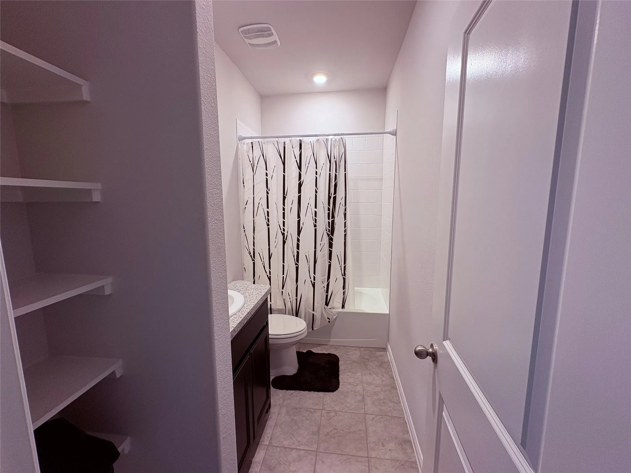 Bathroom with a built-in vanity, integrated sink, and light-toned countertop