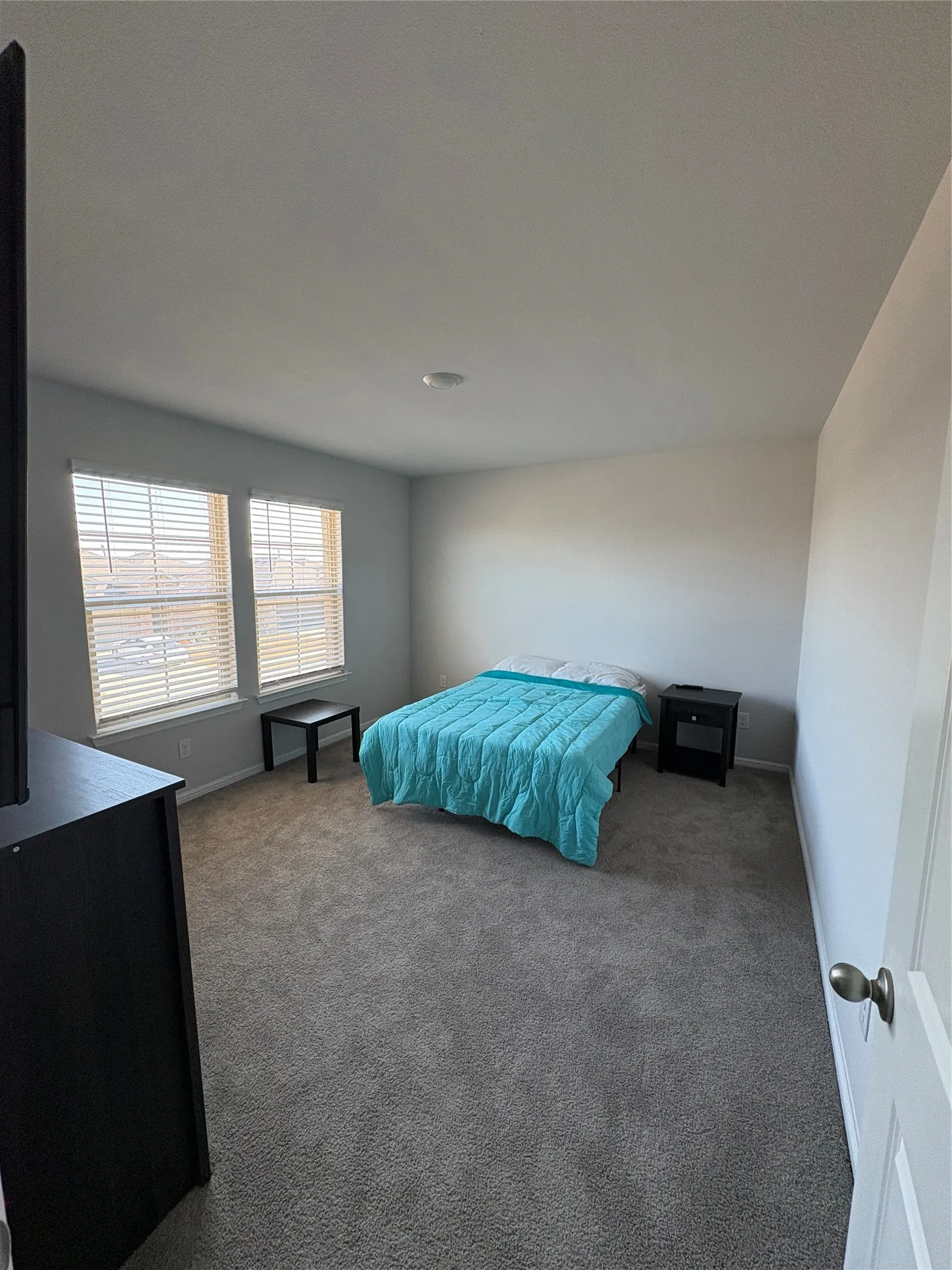 Neutral wall tones, recessed lighting, and carpeted flooring