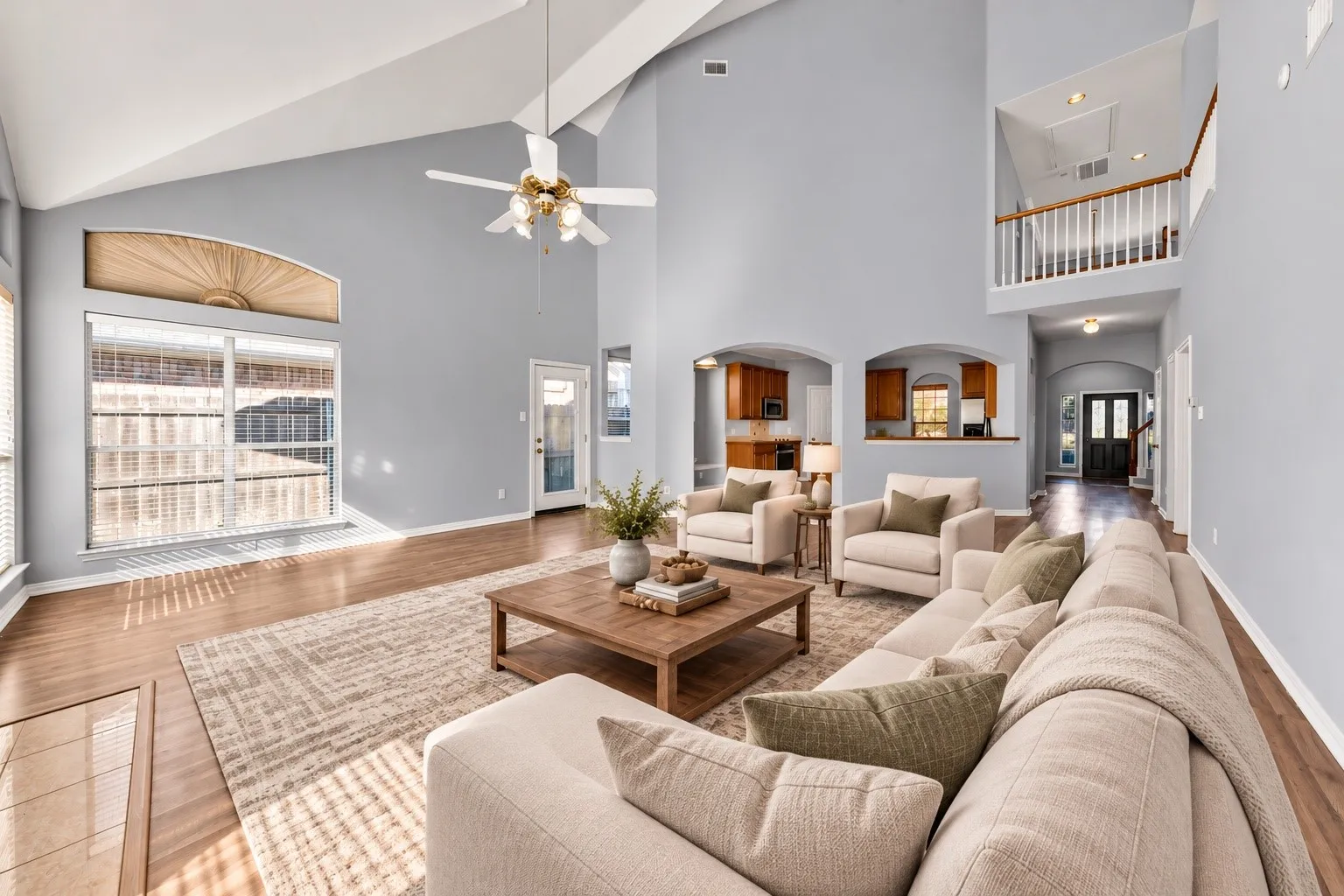 Vaulted ceilings, wood-finish flooring, and arched doorways define this living space