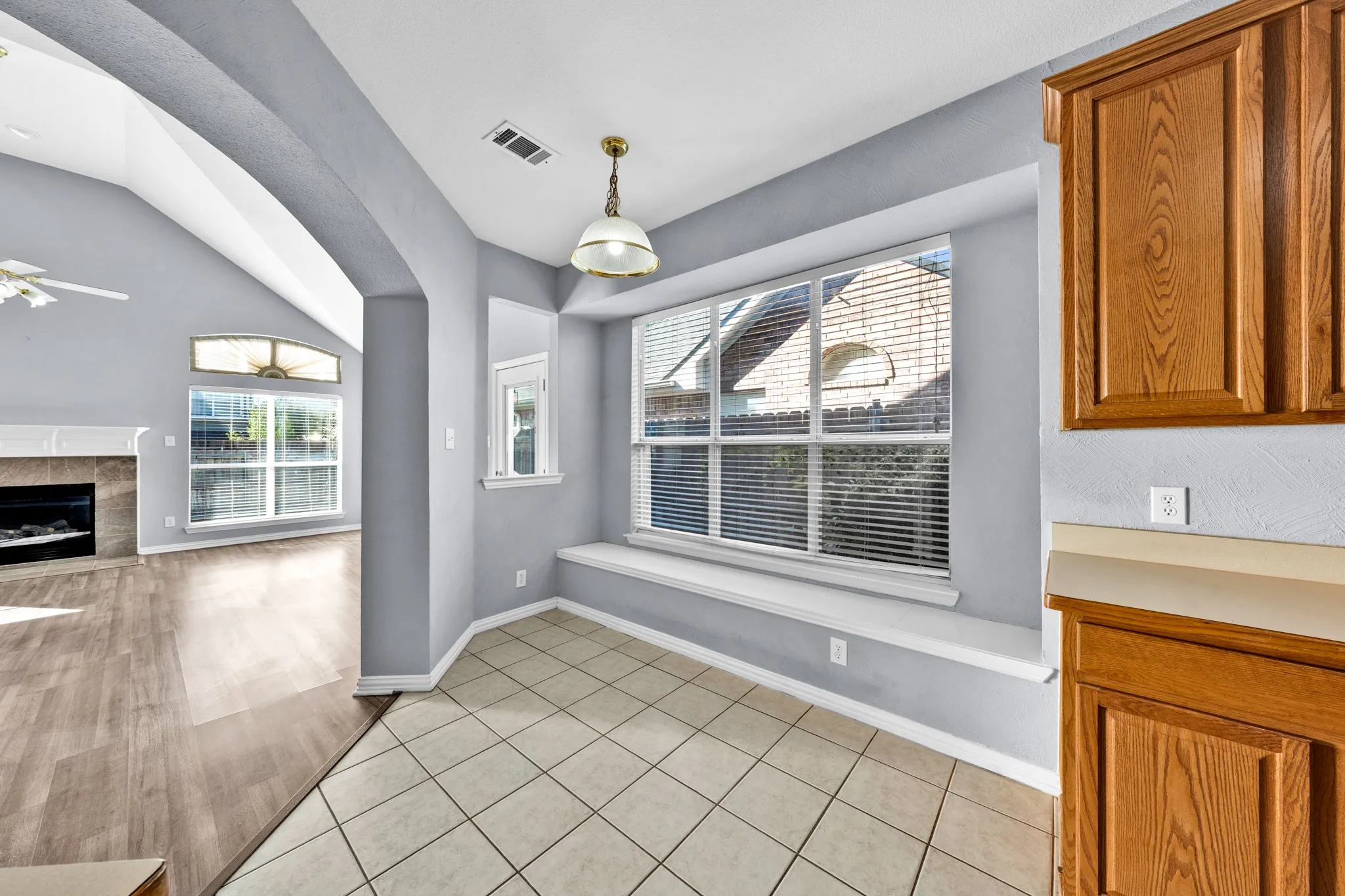 Tiled flooring with a corner window, built-in window seating, and a decorative pendant light fixture