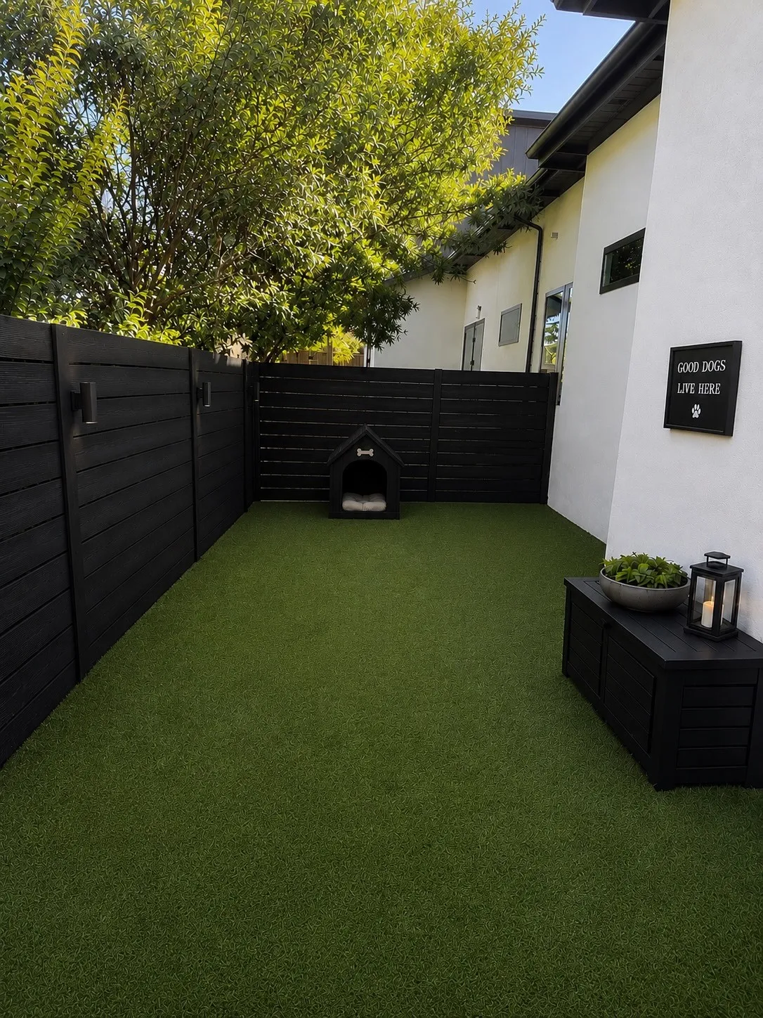 Private dog run outdoor space featuring artificial turf and dark-stained fencing with integrated lighting