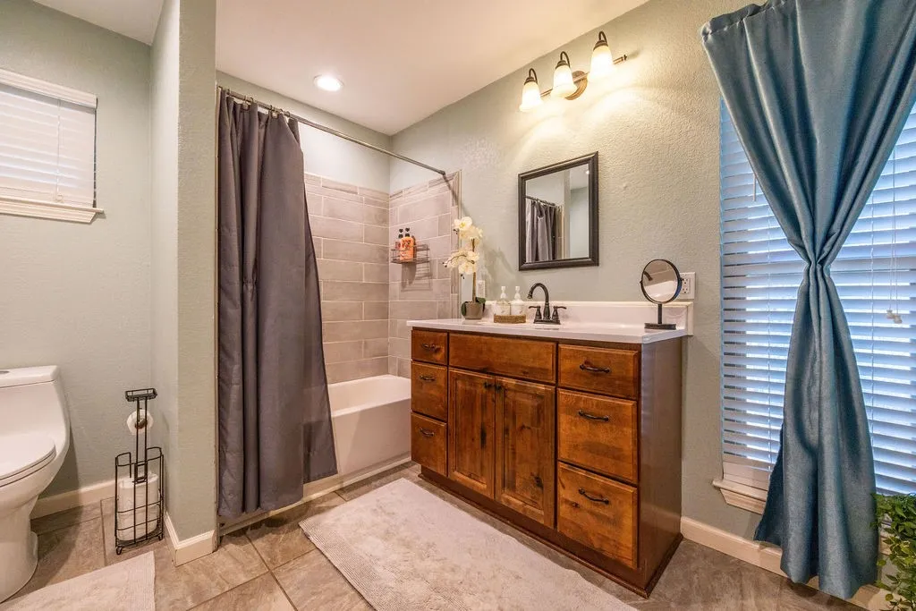 Wood-finish vanity with a white countertop and rectangular sink