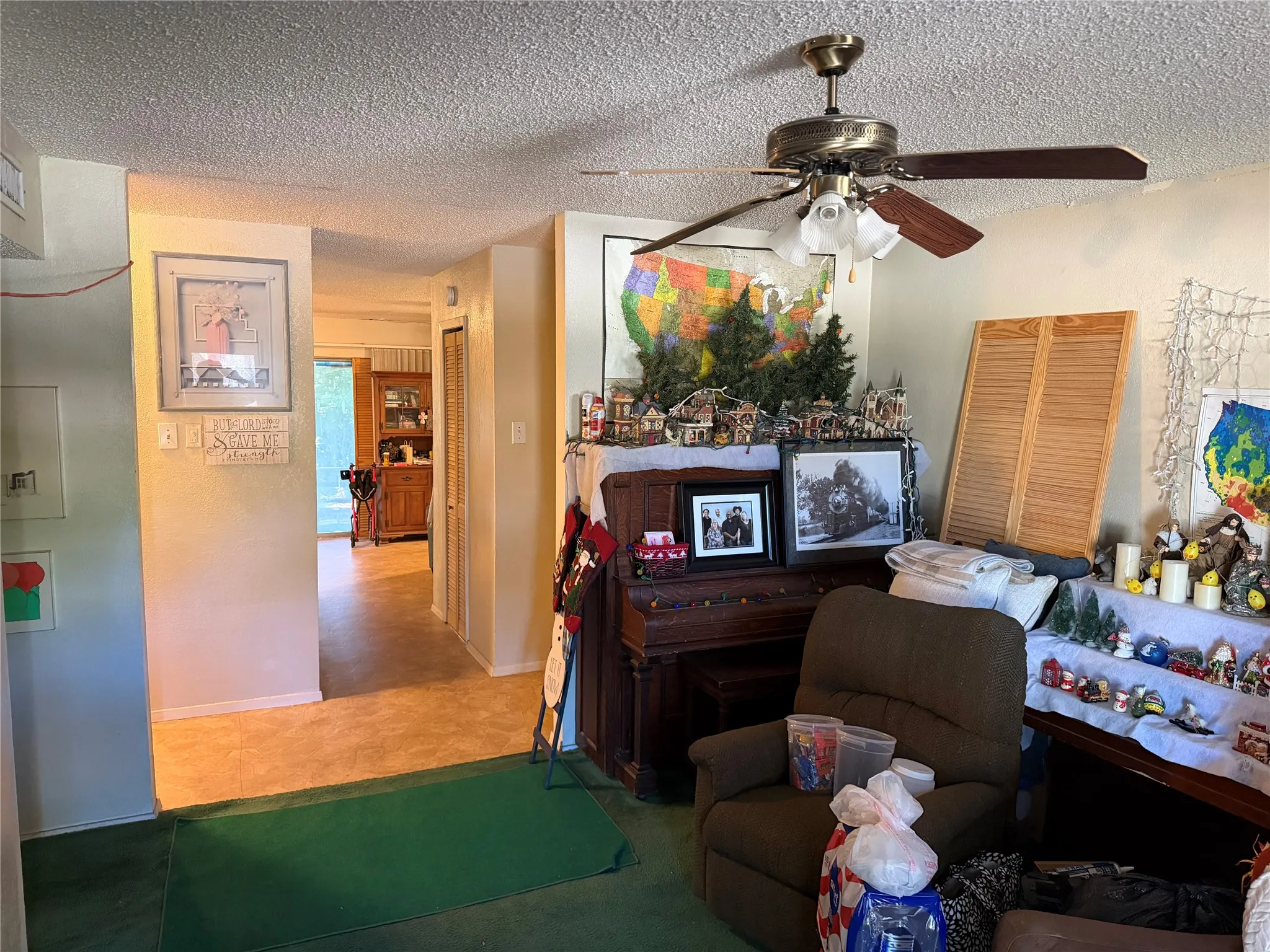 Textured ceiling with a ceiling fan featuring a brass-tone base and wood-finish blades