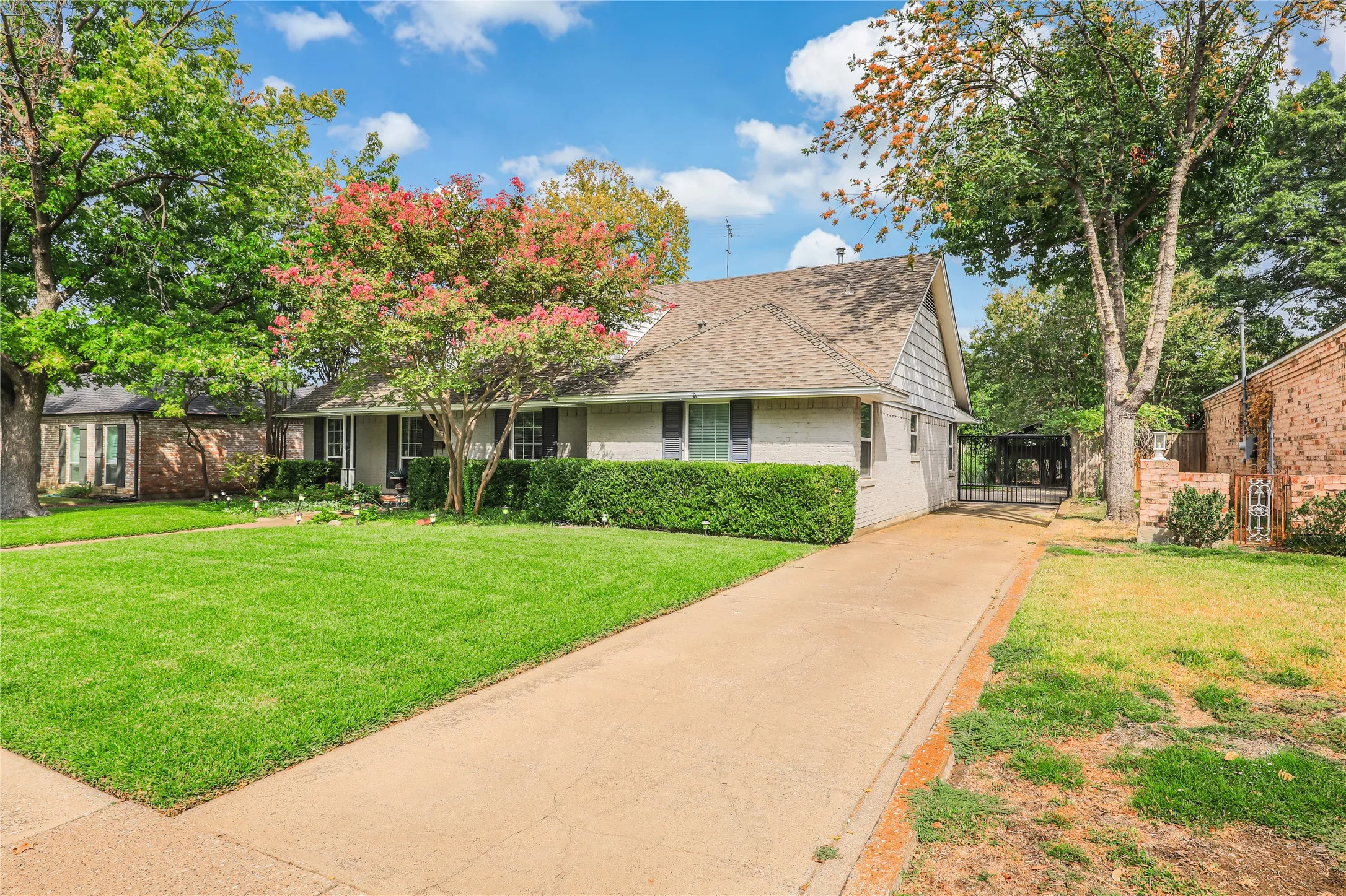 Iron gated  driveway to a lovely backyard with beautiful landscaping and plenty of parking  Three covered parking!