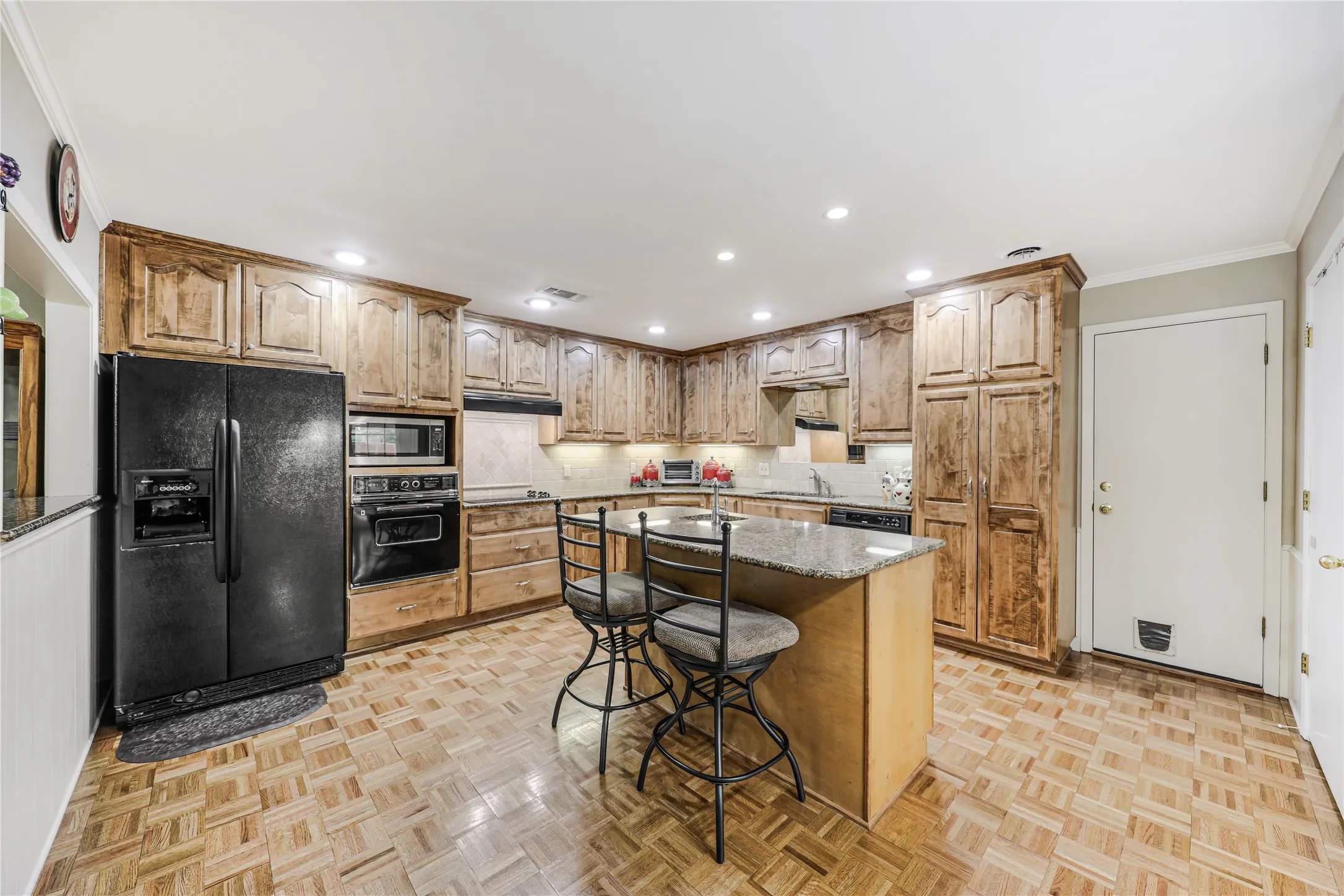 Spacious island renovated kitchen with 42 inch under cabinet lighted cabinets and custom pull outs and built in pantry.  Also extra vegetable sink built-in the island with granite countertops and opens to breakfast area and outdoor patio!