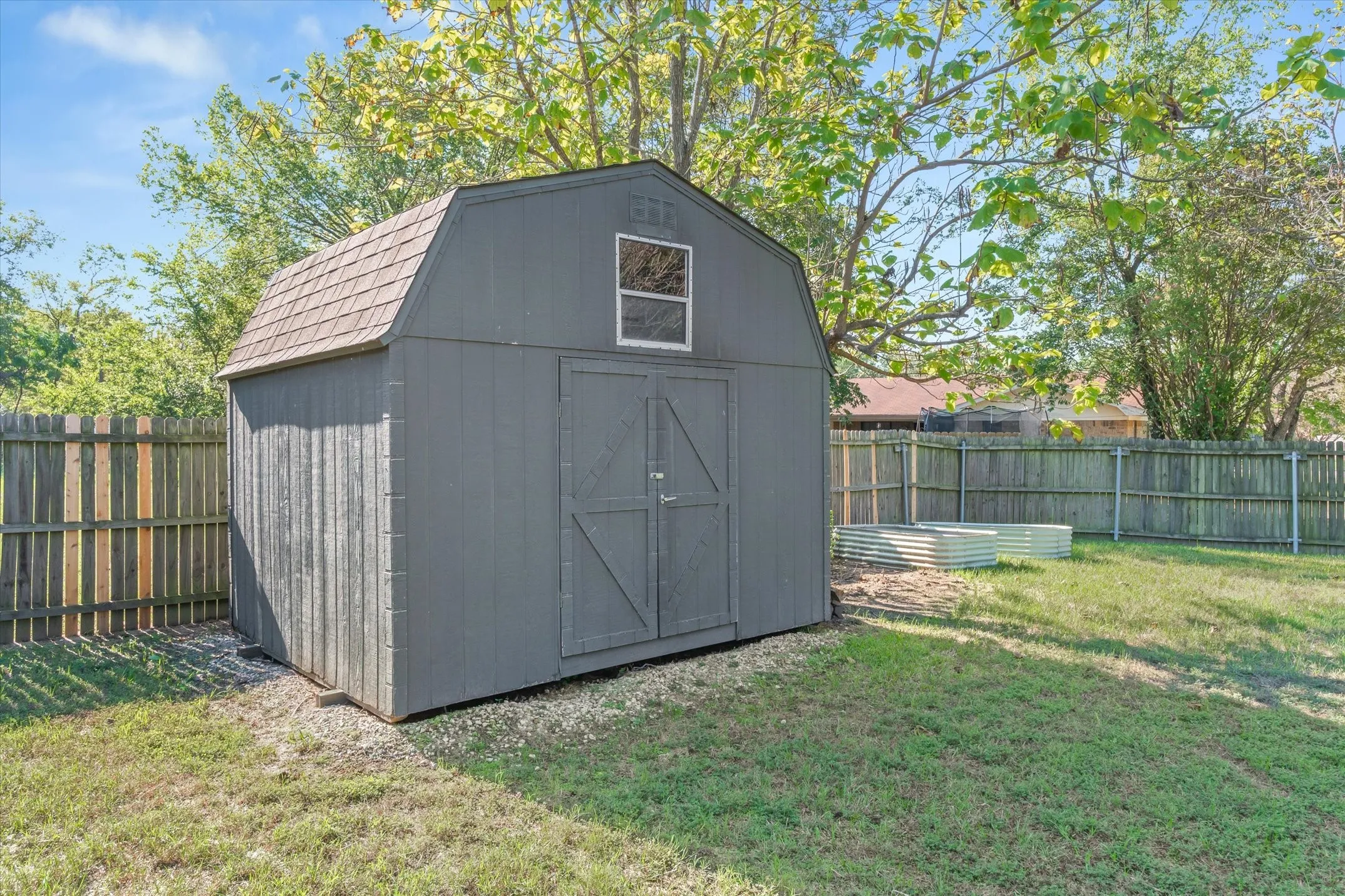 Raised bed garden area and a 12x12 storage building with loft area and workbench
