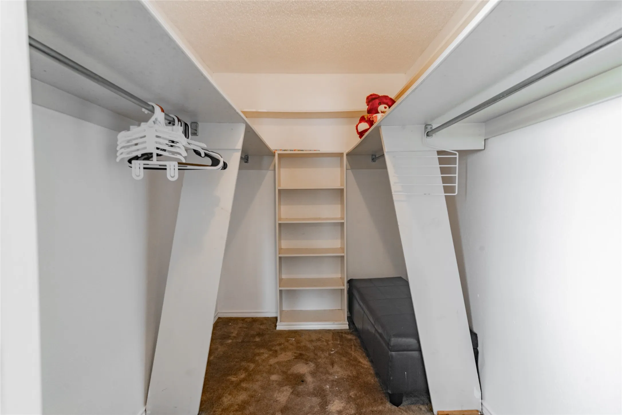 Built-in shelving unit, dual clothing rods, and white painted walls