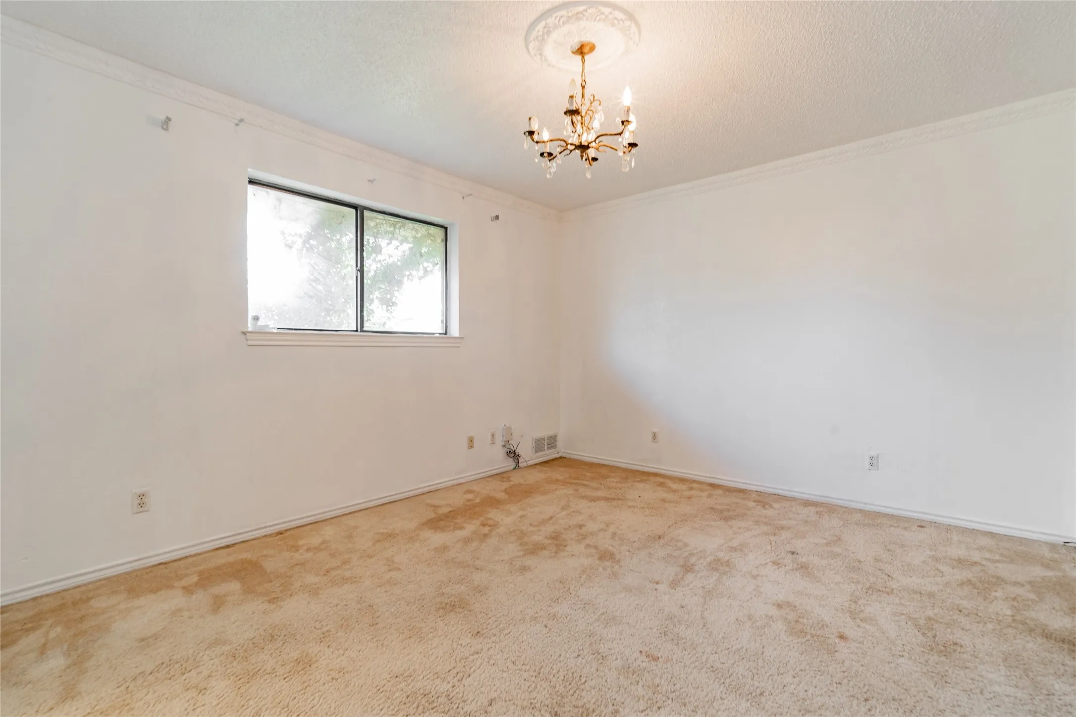 Crown molding and a decorative ceiling medallion complement the overhead chandelier