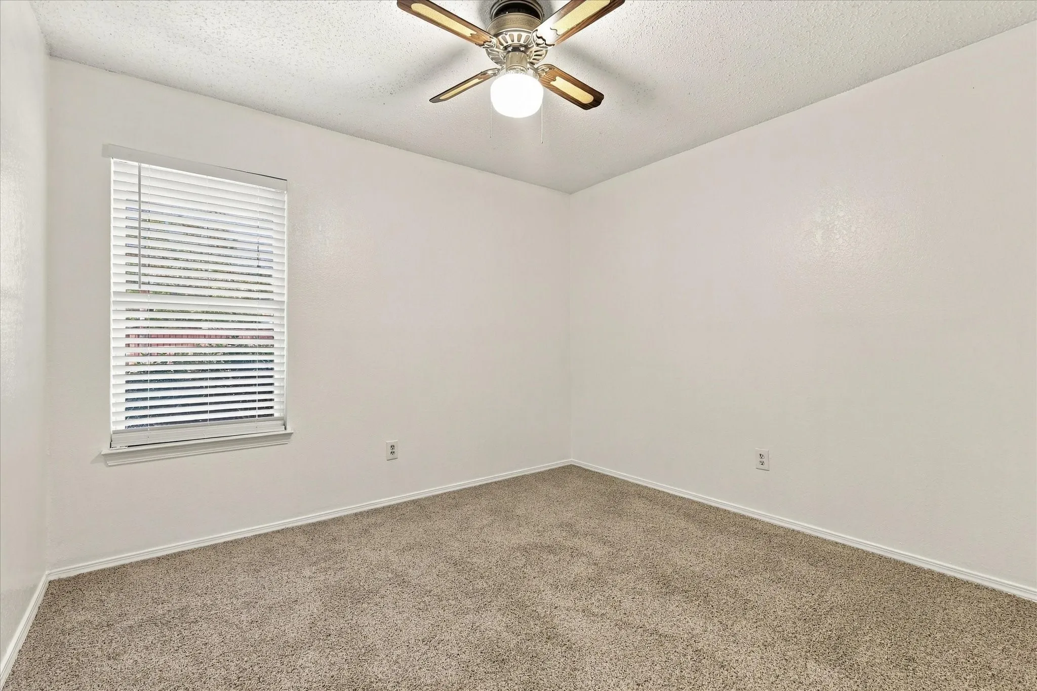 Window with blinds, ceiling fan with integrated lighting, and neutral carpet flooring