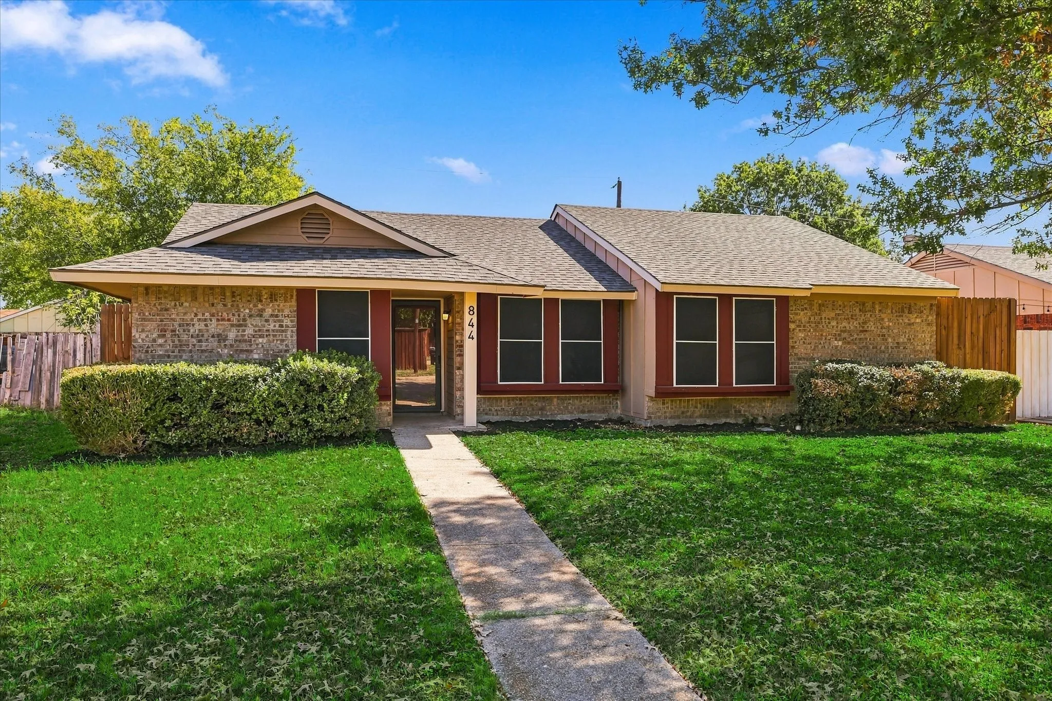 Brick and siding exterior with red window trim
