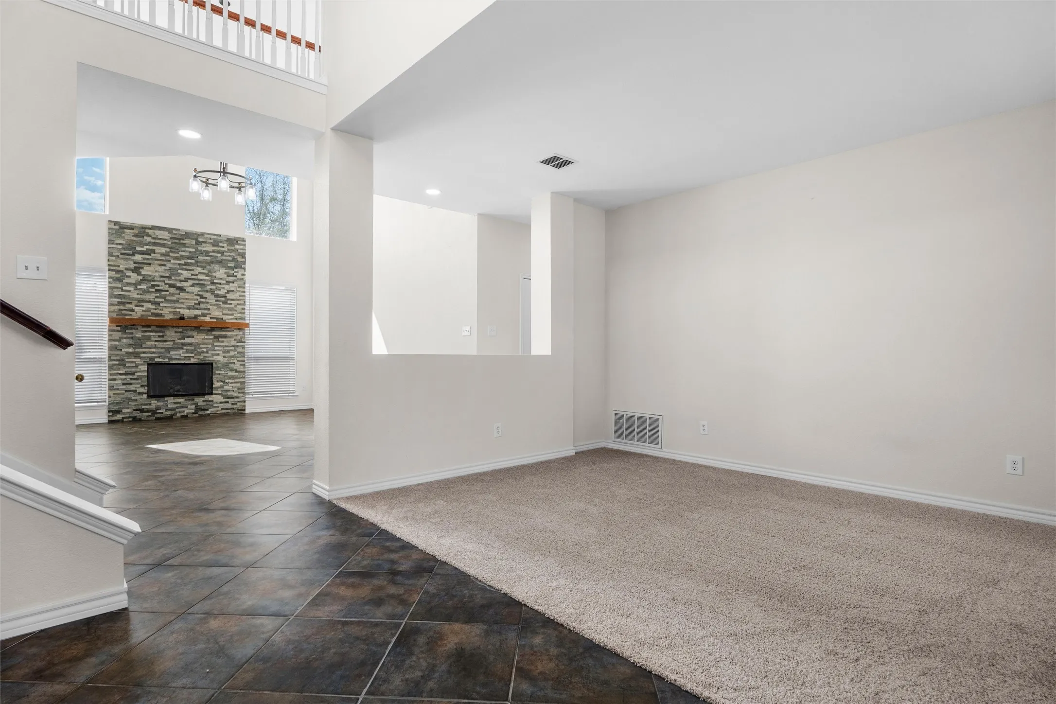 Two-story interior with a stone-clad fireplace and wood mantel