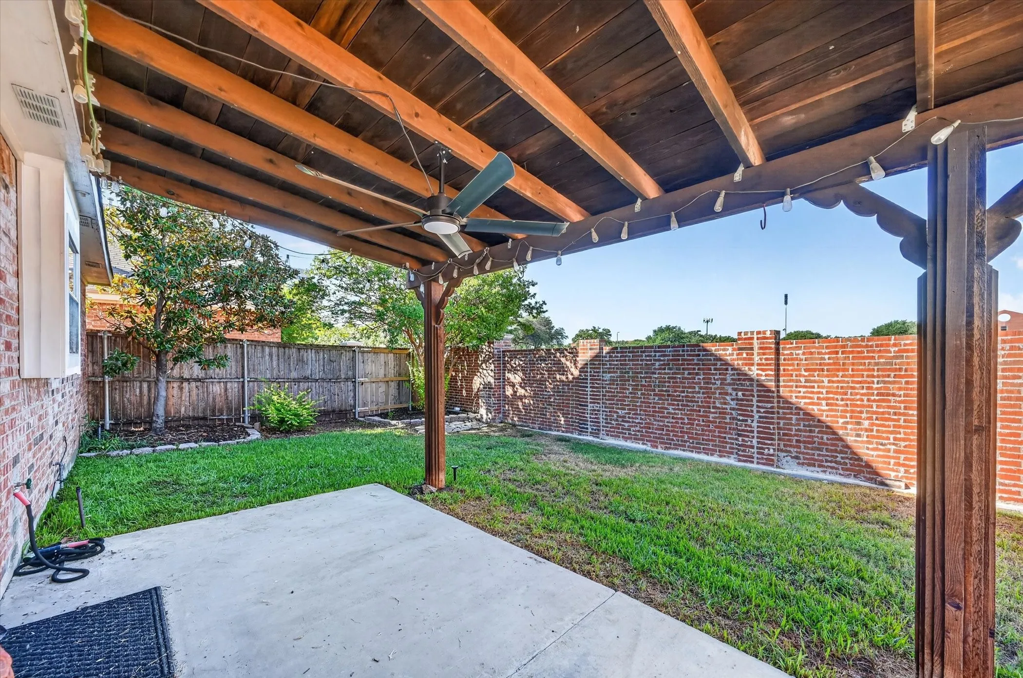 Covered patio featuring a wood ceiling, ceiling fan, and concrete flooring