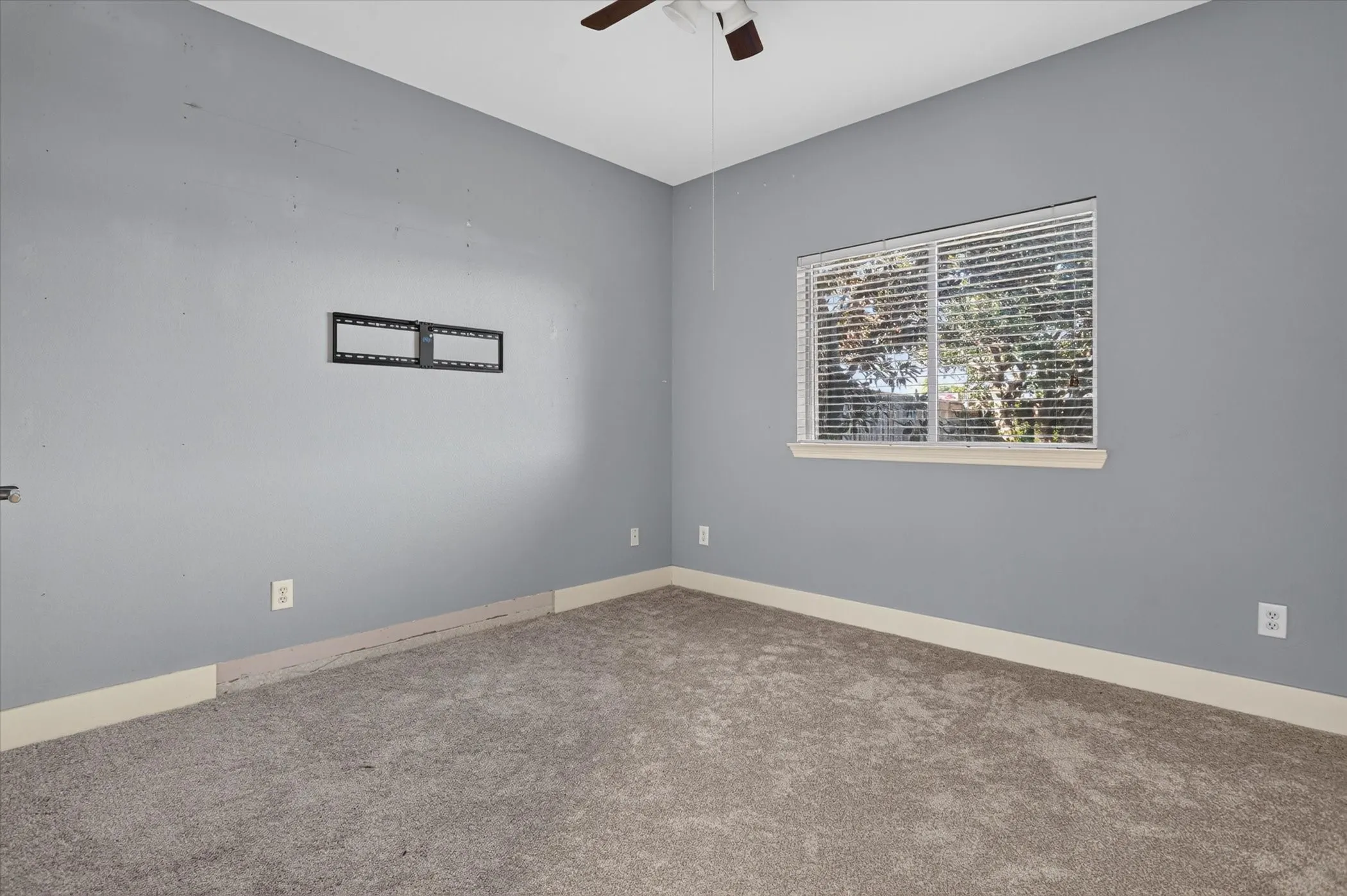 Neutral-toned wall paint, neutral carpeting, horizontal window blinds, and ceiling fan with integrated lighting