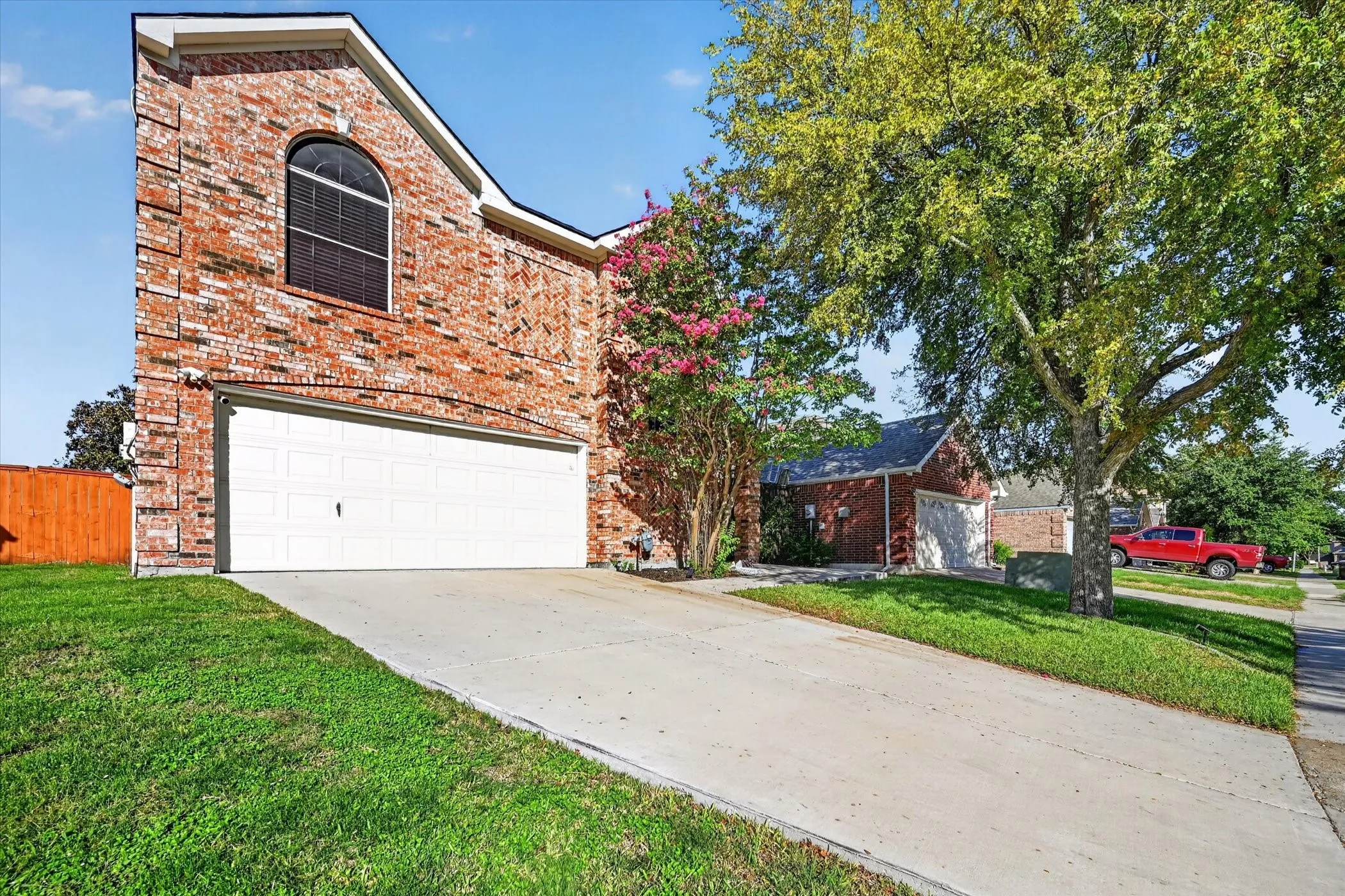 Brick exterior with arched window and white garage door