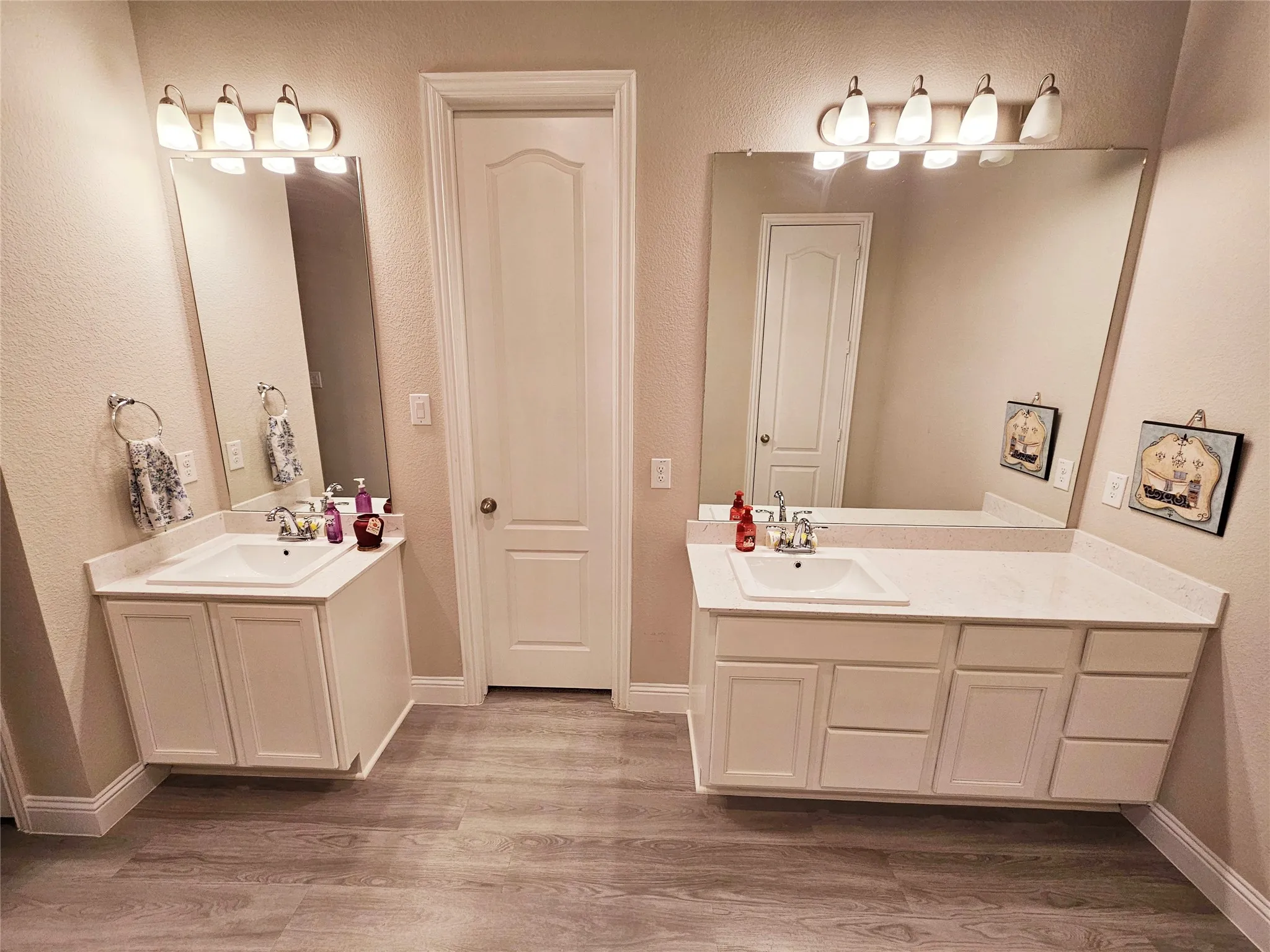 Dual vanity sinks with white cabinetry, integrated countertops, and individual mirrors