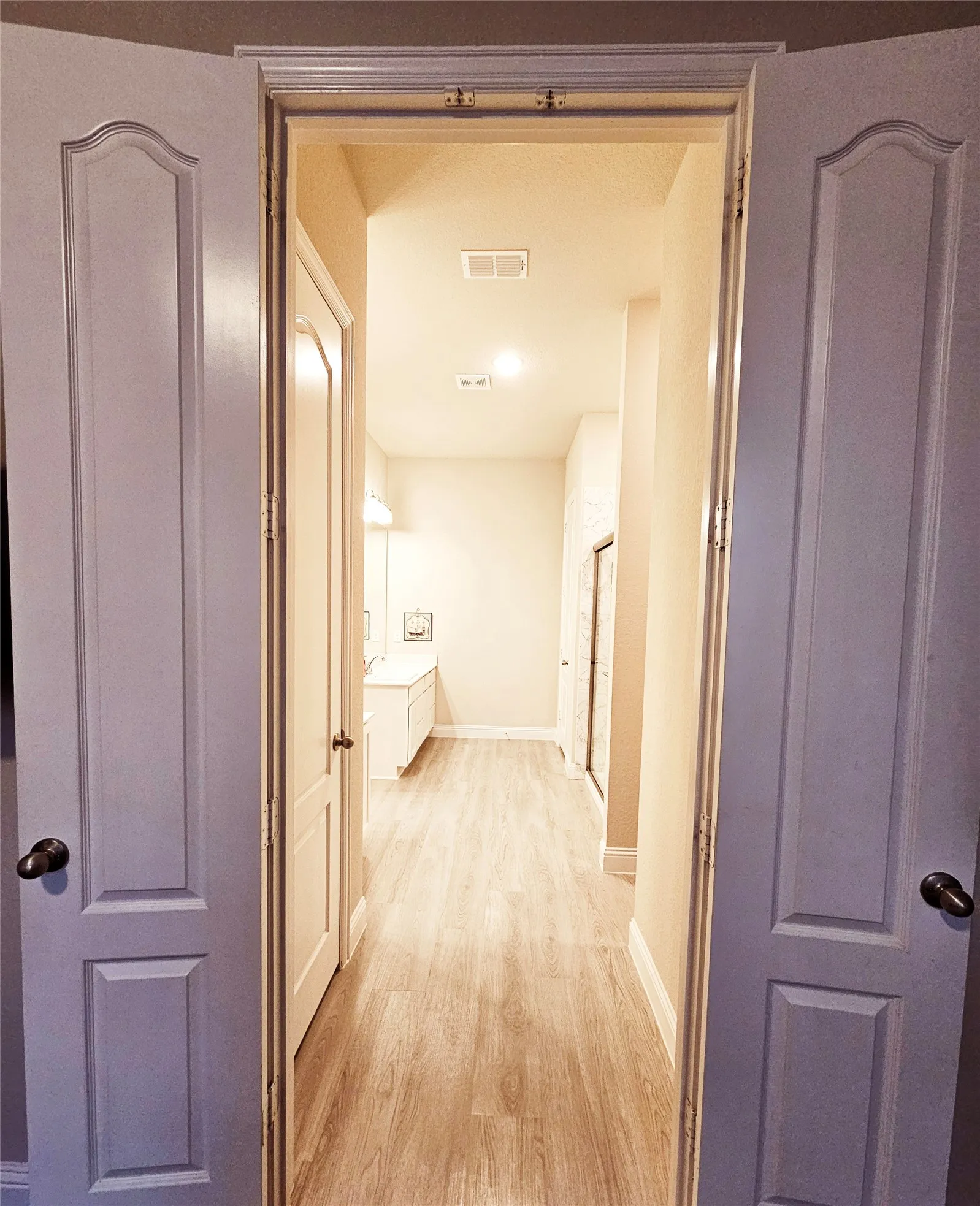 Light wood-finish flooring extending through the hallway