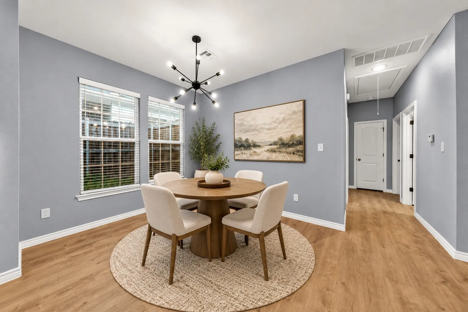 Recessed lighting, wood-finish flooring, and a modern chandelier