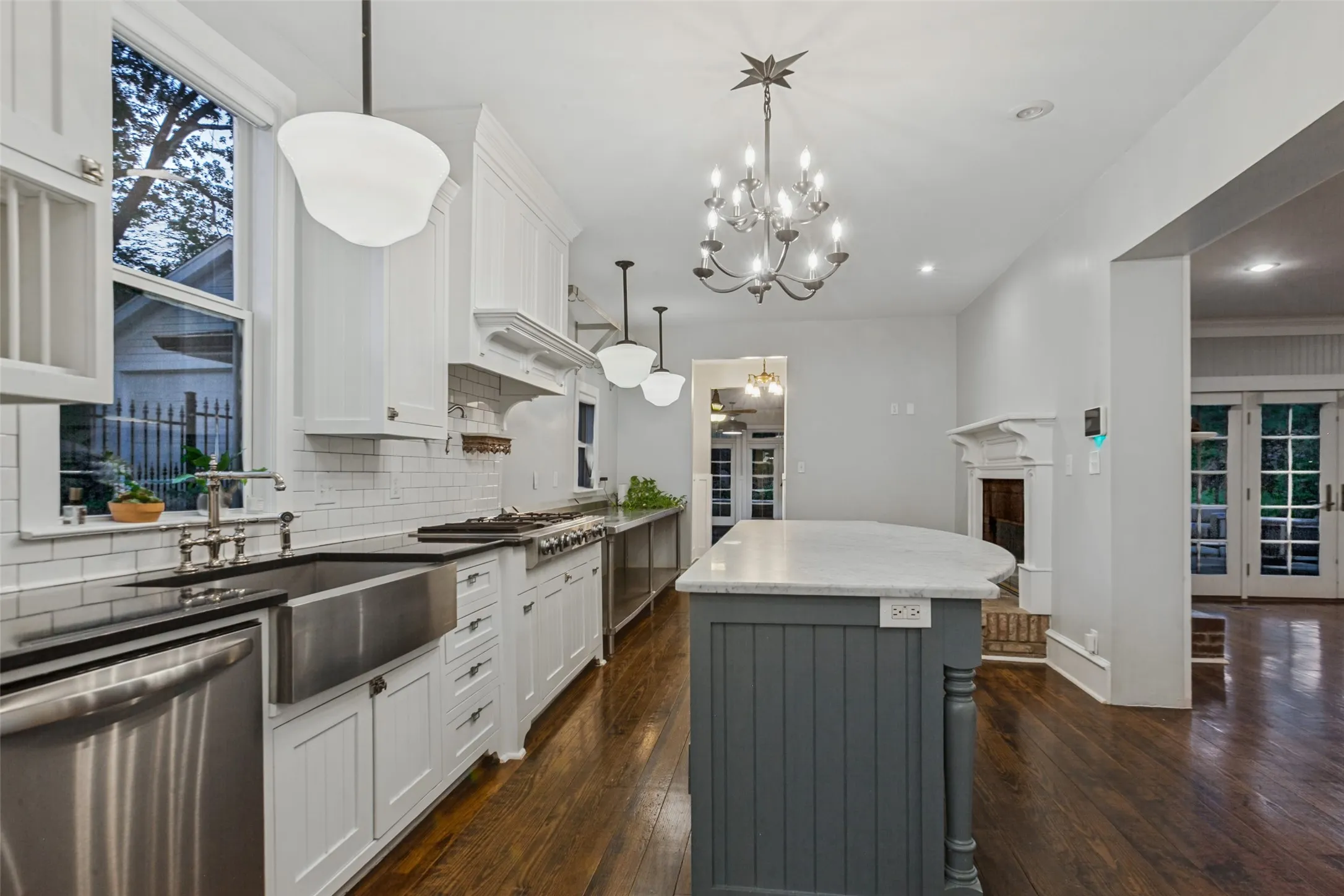 View of kitchen from hallway with wet bar featuring marble island and fireplace