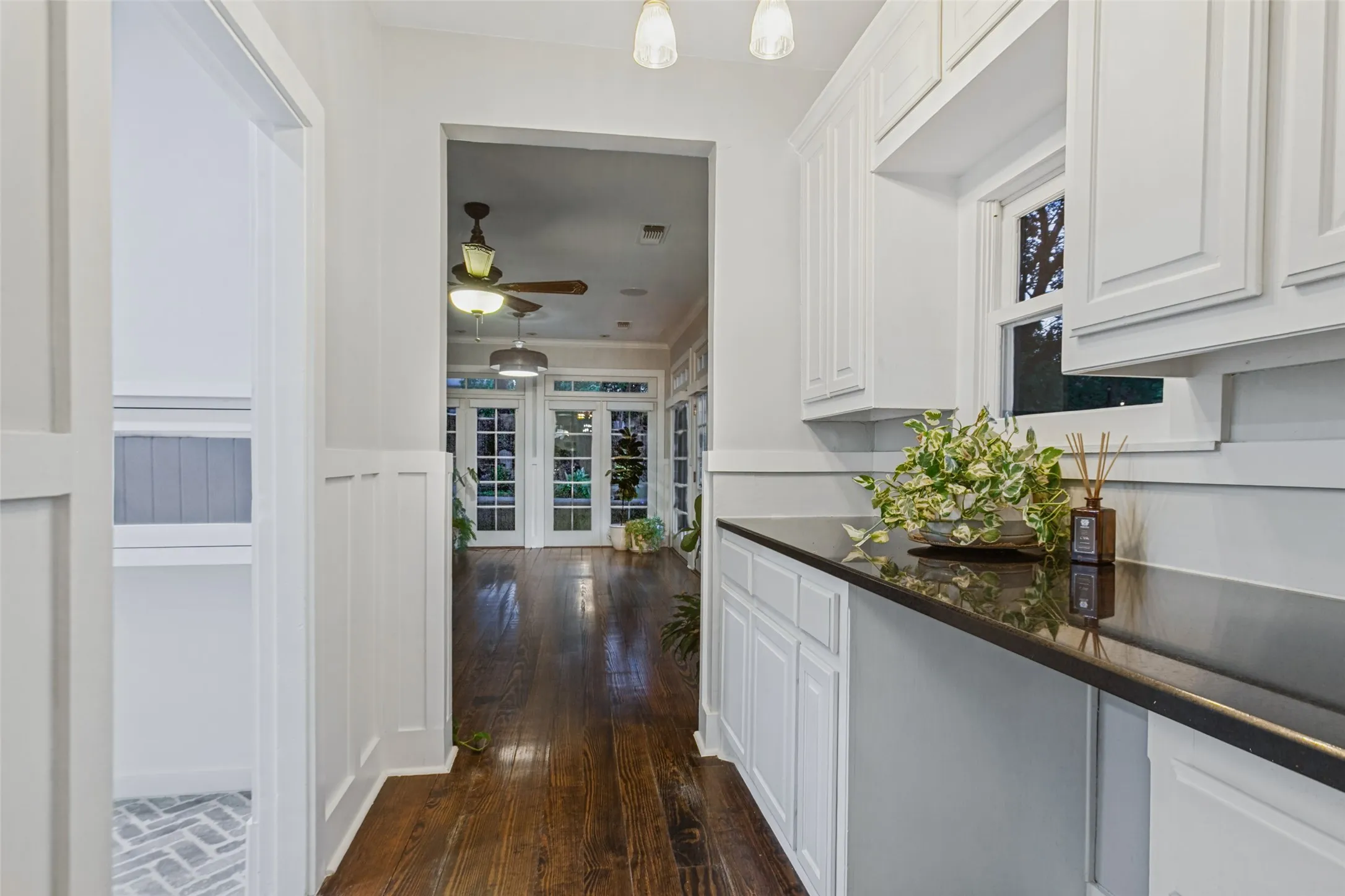 Hallway from kitchen leading to second living area, the solarium, and entryway to Utility room, garage and storage room