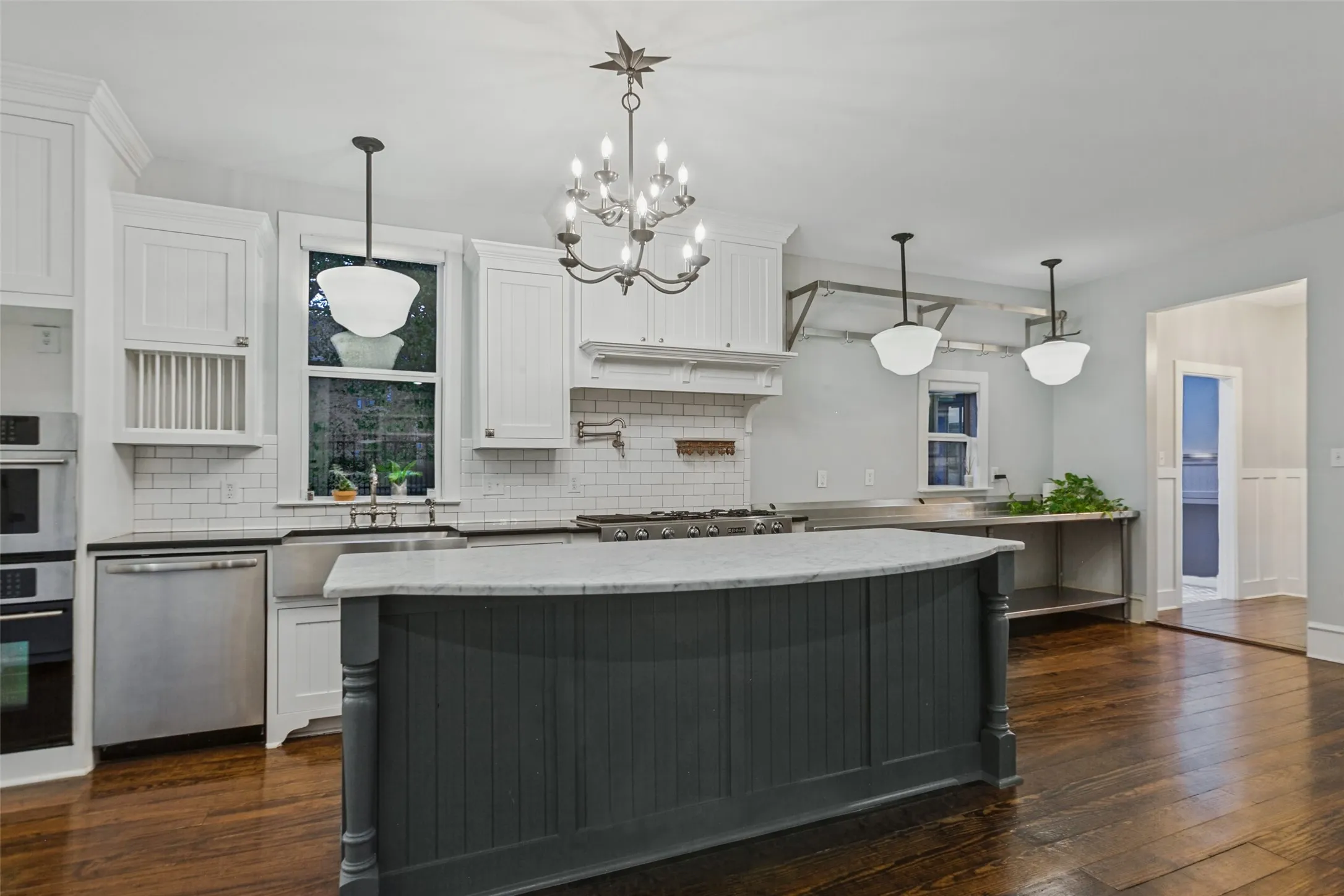 View of kitchen from living room with subway tile, stainless steel appliances, gas range, and commercial grade prep station