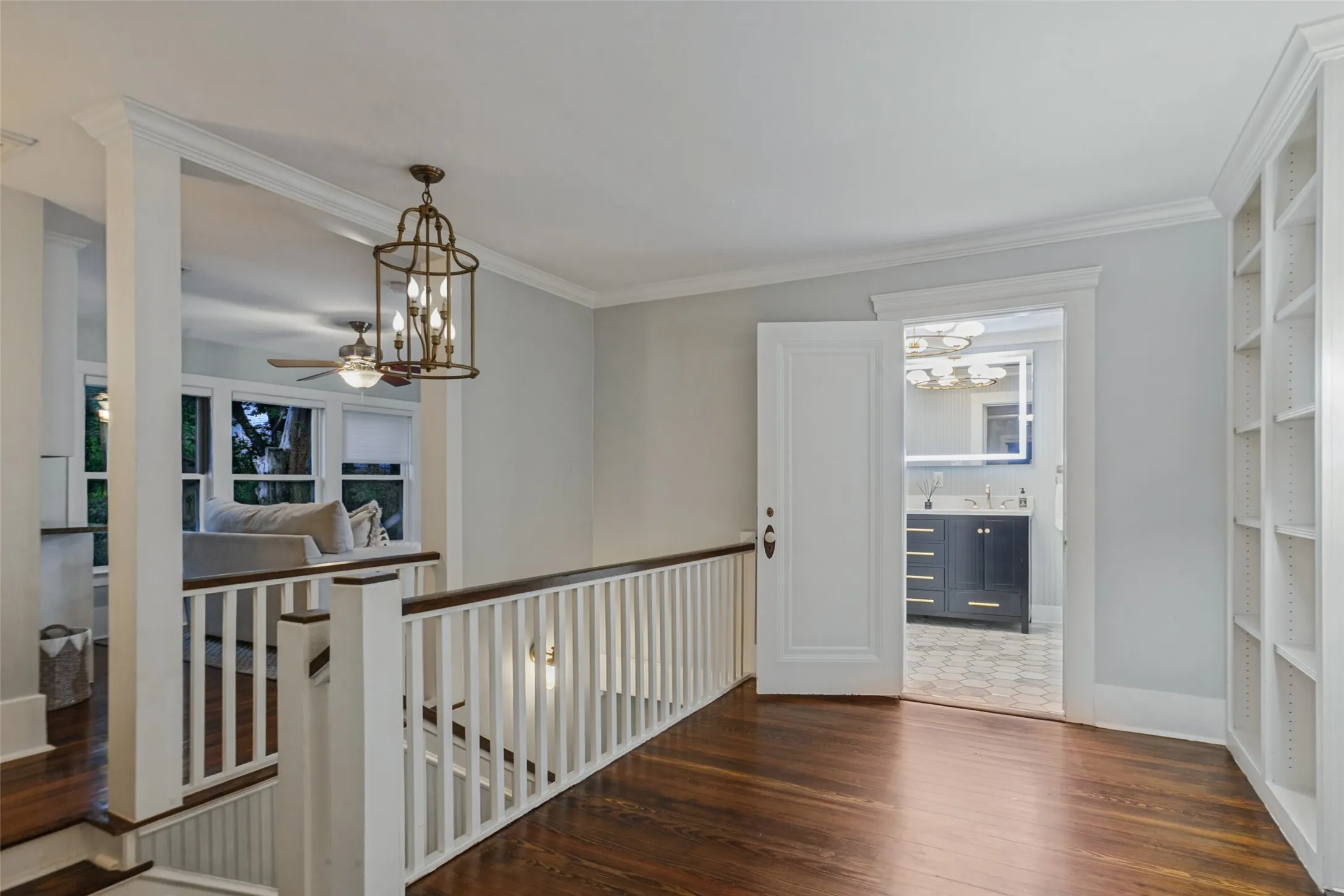 View of main staircase from upstairs showing sitting room, full upstairs bathroom, and media room