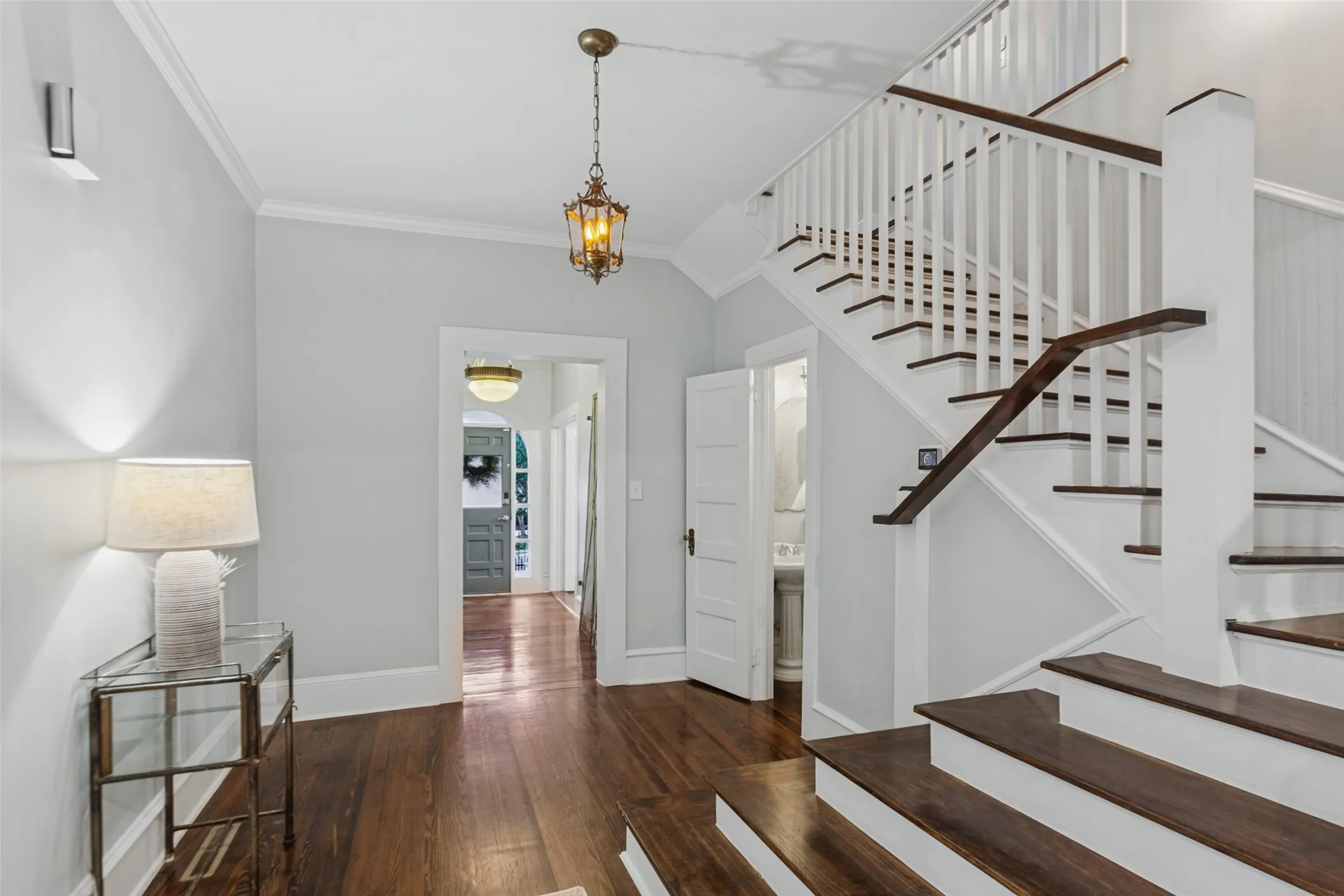 View of front door, entryway and main staircase. Adorable half bathroom located under the staircase