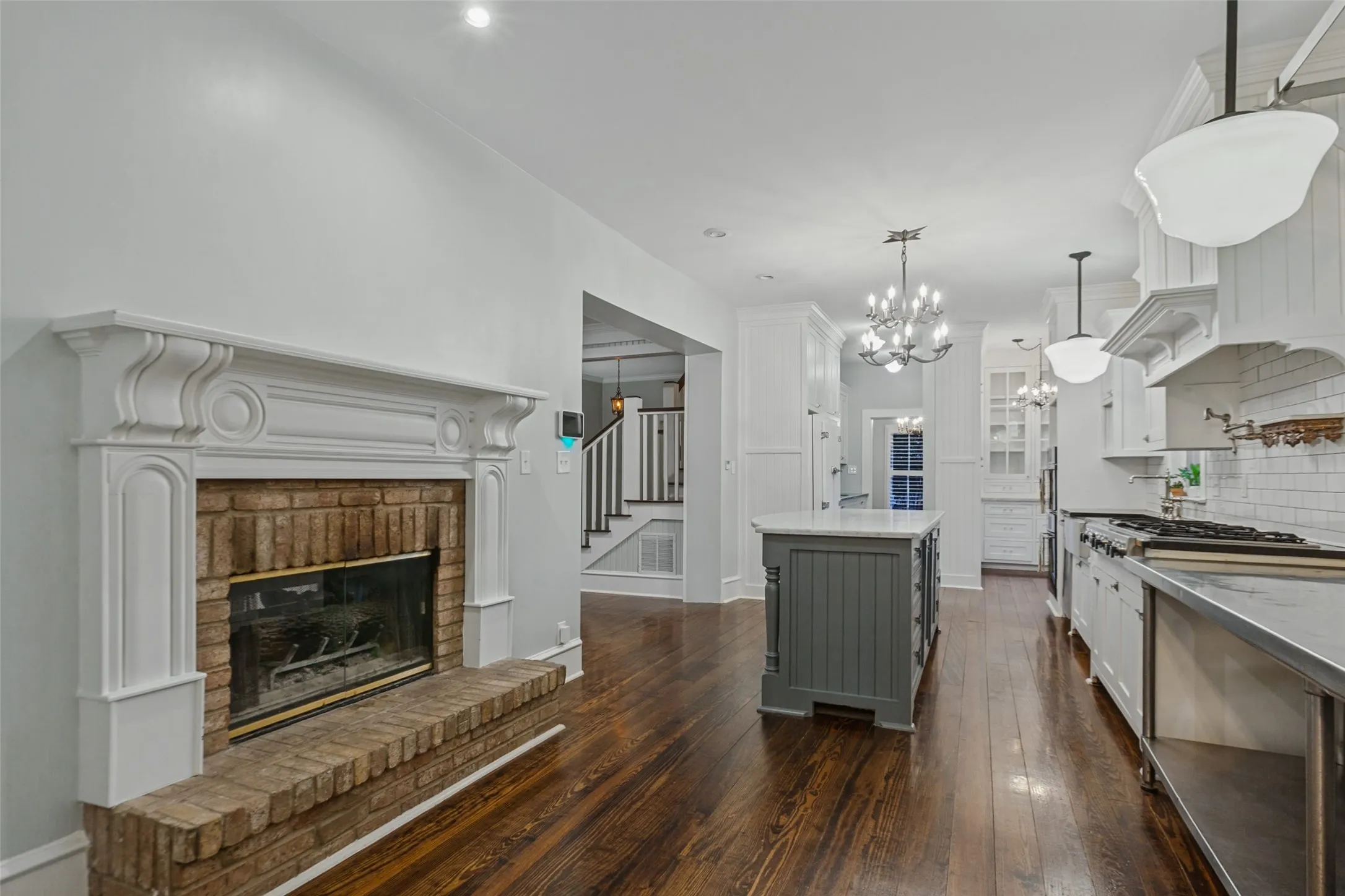 View of kitchen from breakfast nook, showing fireplace and pantry area