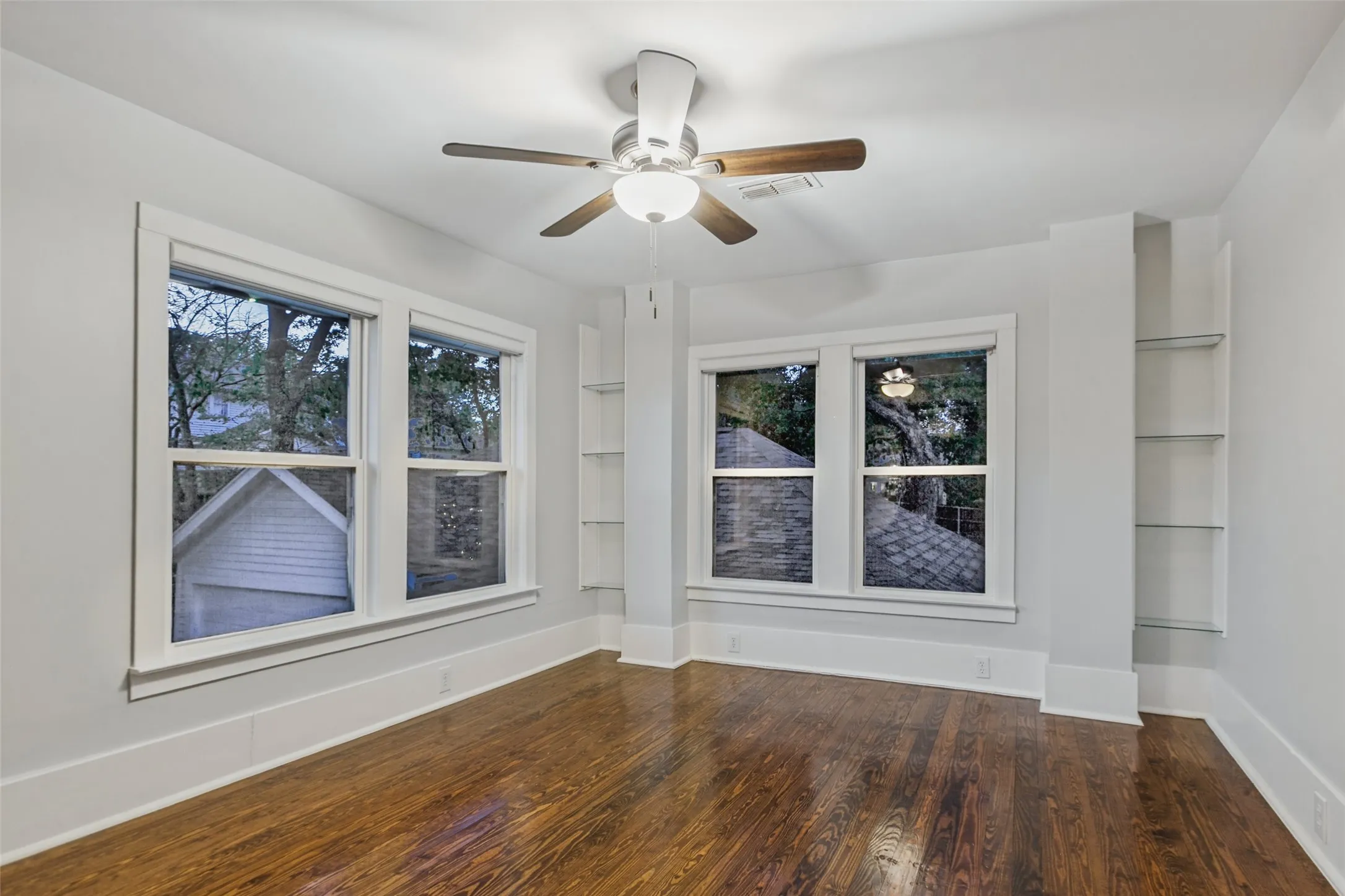 Upstairs bedroom facing backyard with built in shelving and armoire