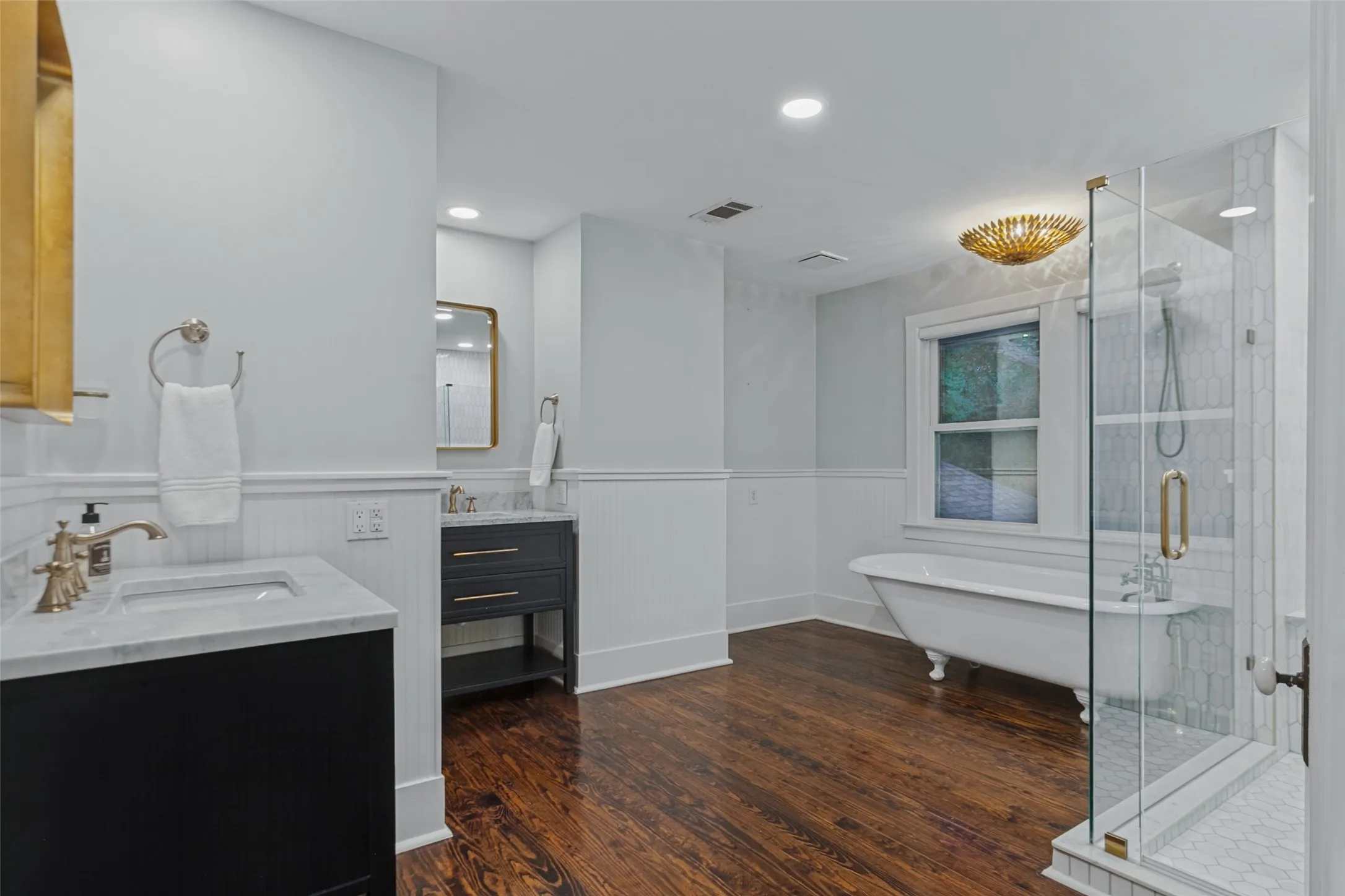 Primary bathroom with claw tub, shower, duel vanities, and separate toilet room
