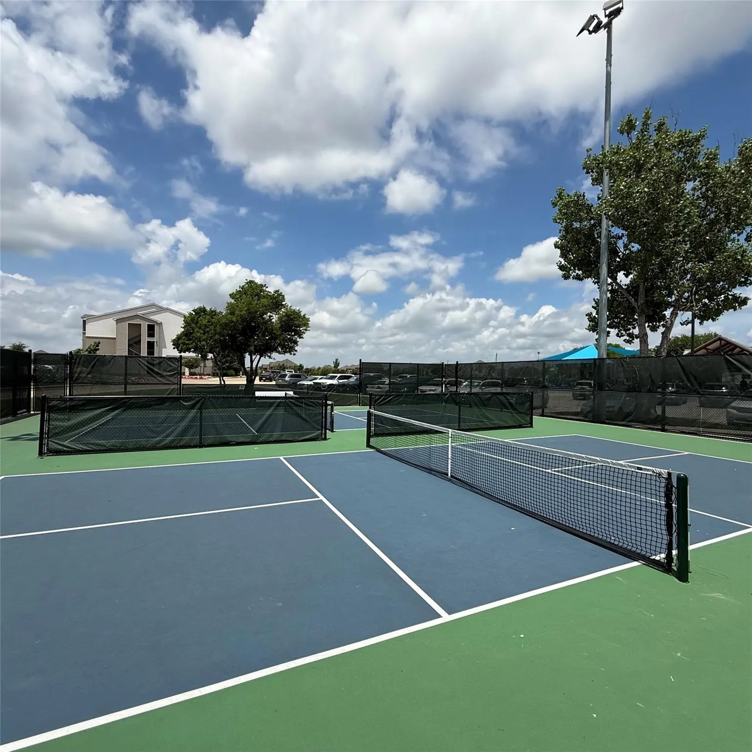 Outdoor hard-surface court featuring a net and boundary lines