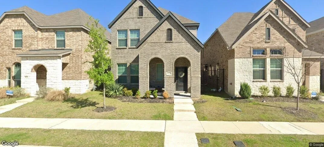 Brick and stone exterior with arched entryways, gabled rooflines, and a concrete walkway