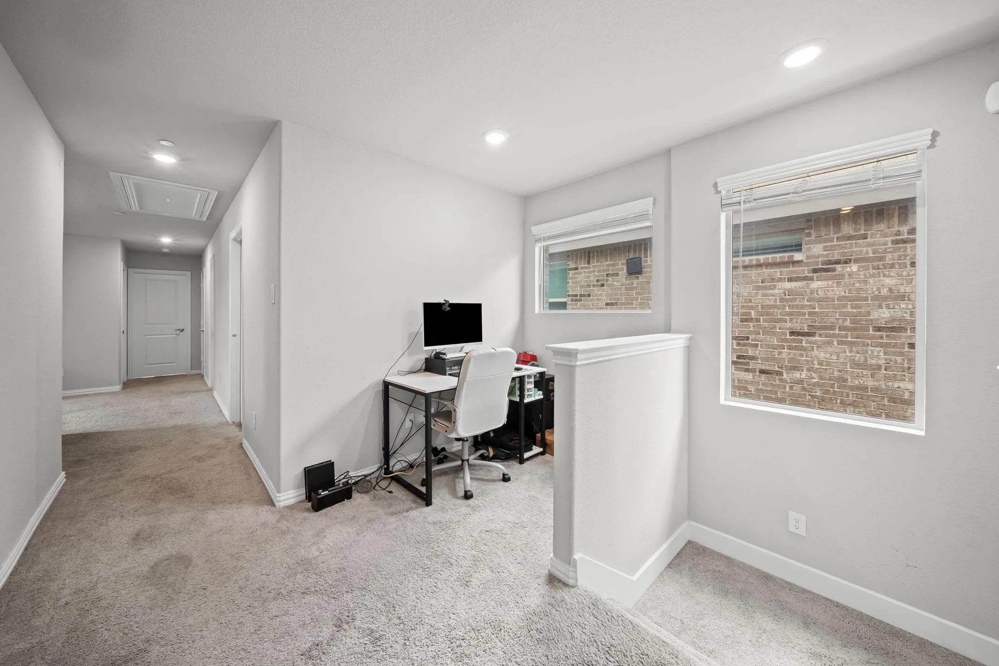 Recessed lighting, light-toned carpeting, white interior doors, and two windows