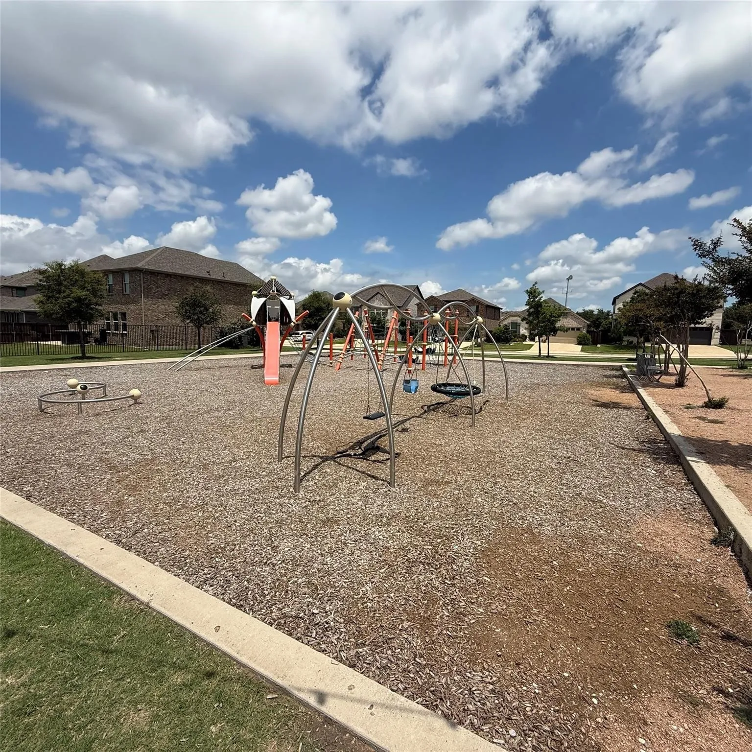 Community playground featuring multiple play structures, swings, and a slide