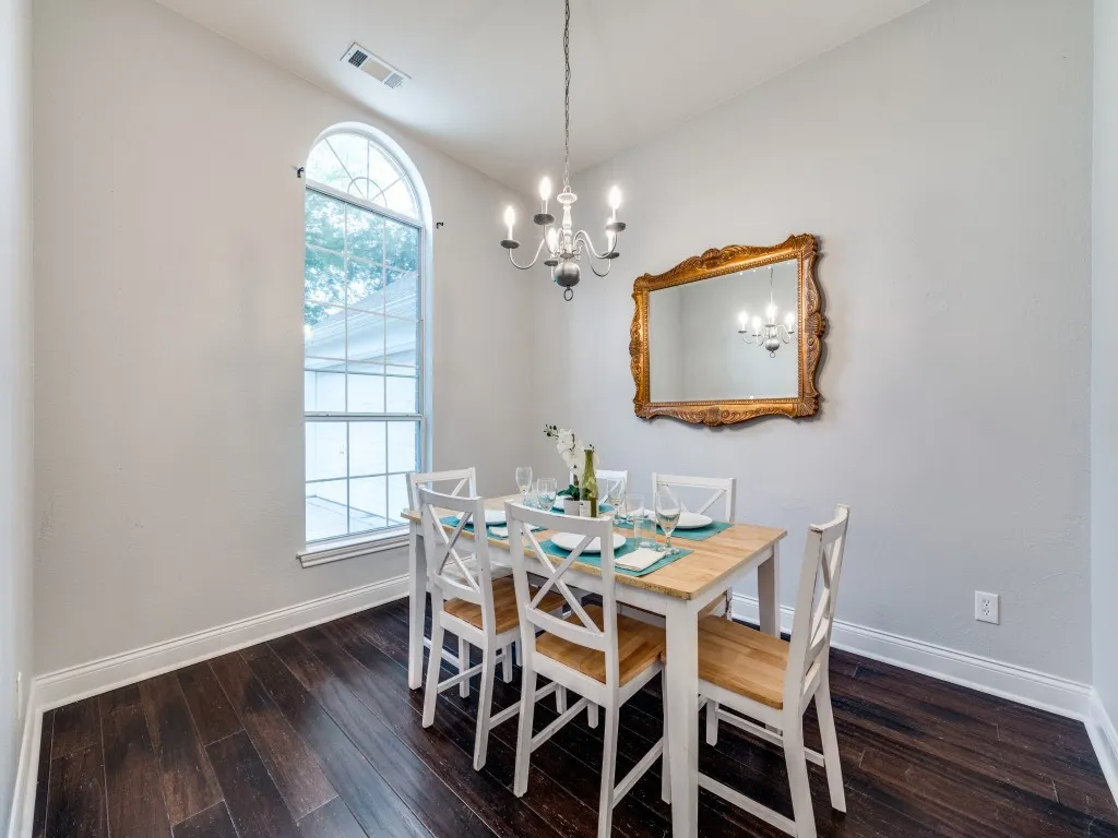 Arched window, wood-finish flooring, high ceilings, decorative chandelier, and crown molding