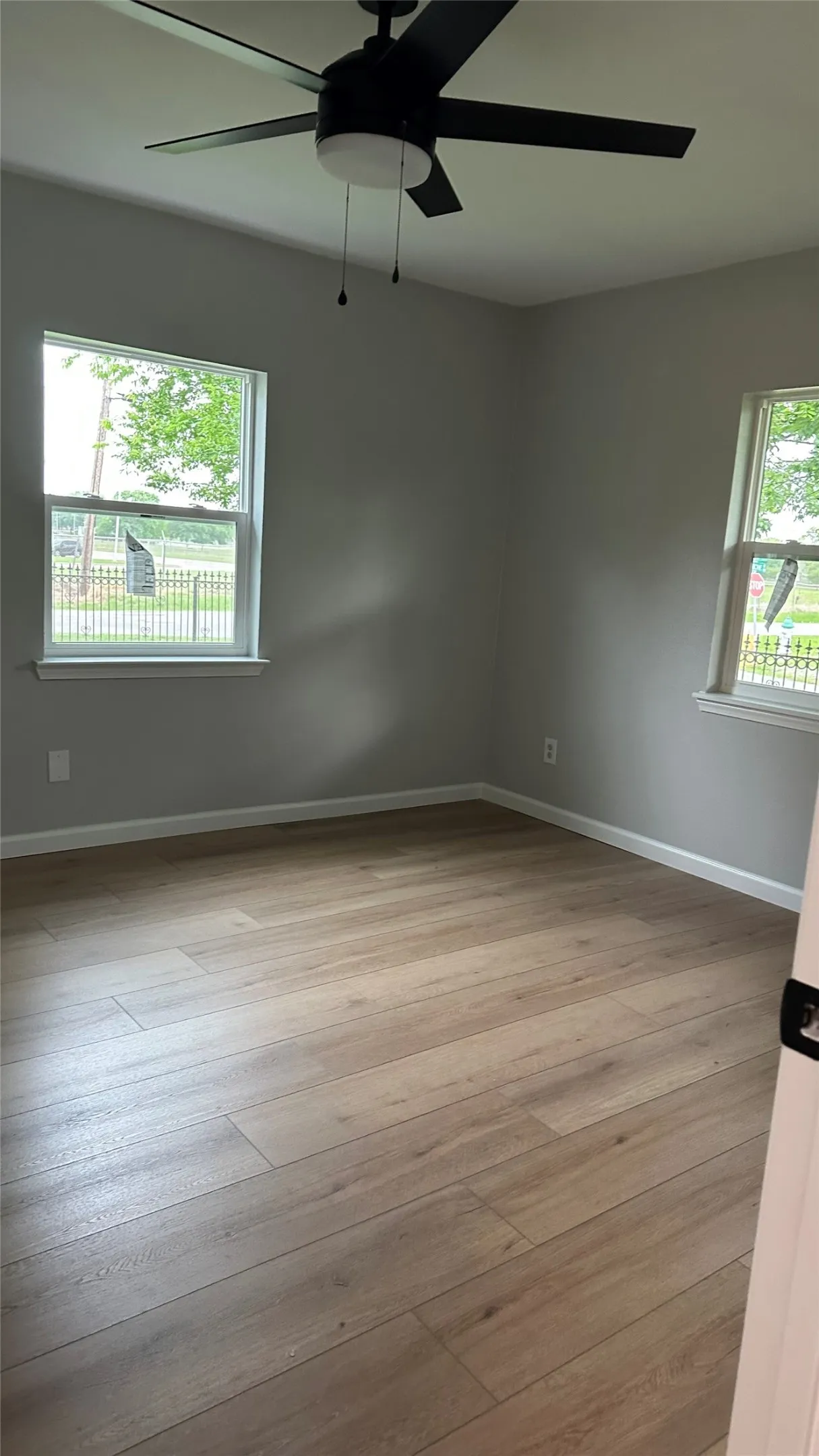 Wood-finish flooring with a neutral paint palette and two windows
