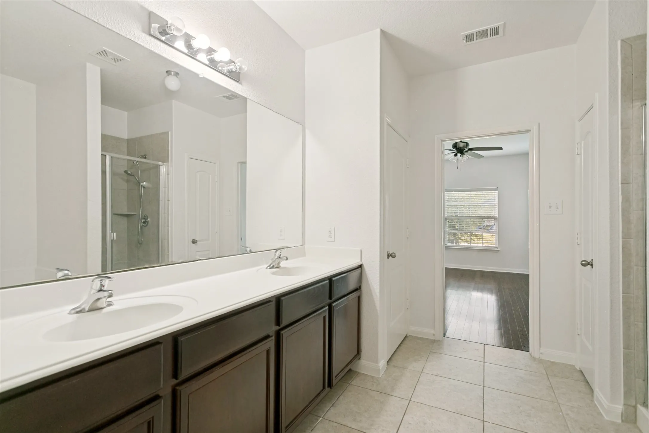 Dual vanity with undermount sinks, chrome fixtures, and dark wood-finish cabinetry