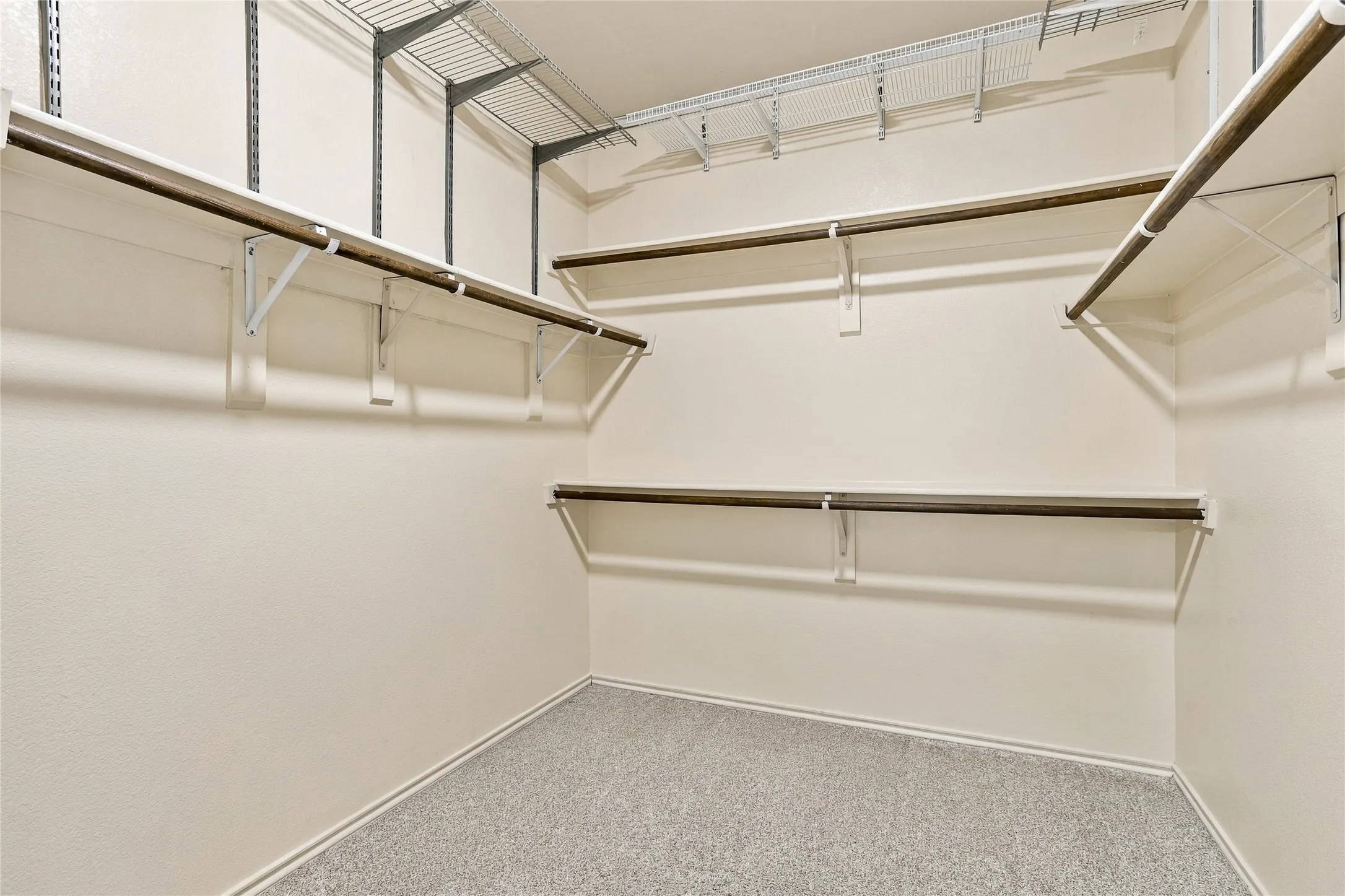 Primary bedroom closet with multiple shelves for storage and for hanging seasonal clothing.
