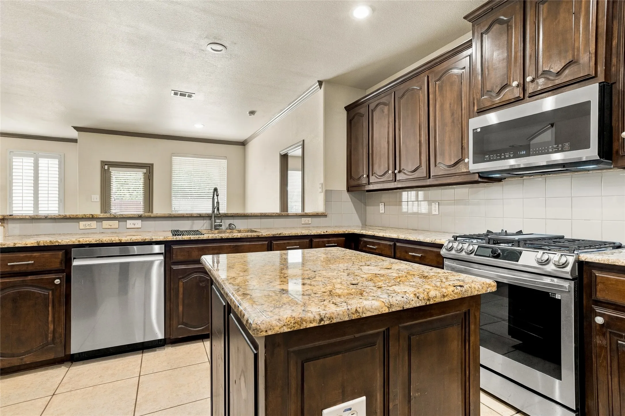 Updated kitchen with stainless steel appliances, granite countertops, spacious island.