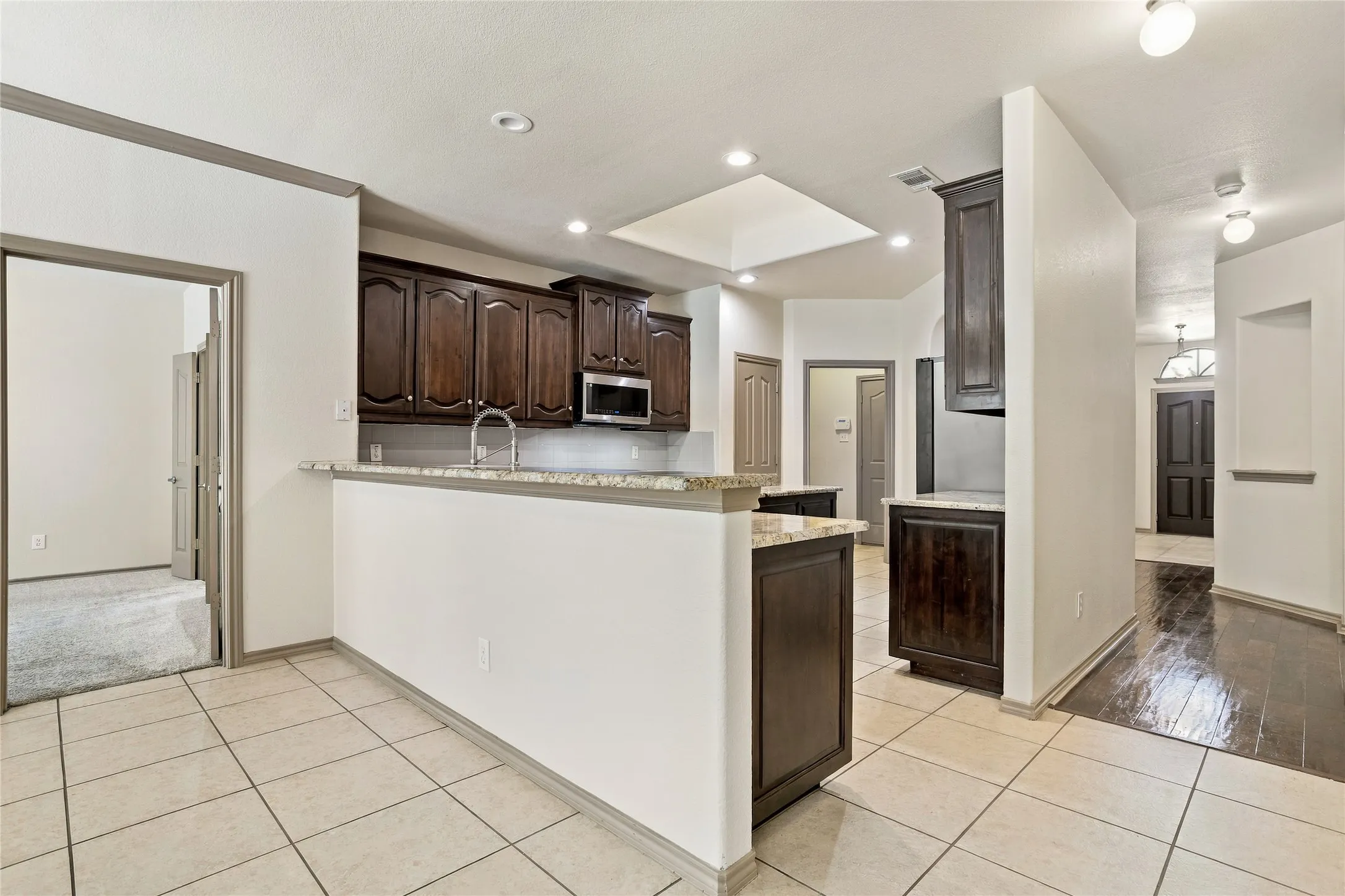 Kitchen area overlooks family room. Bar chairs fit nicely at the counter for extra eating area.