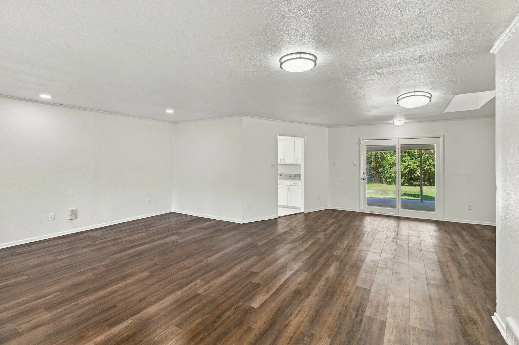 Wood-finish flooring, recessed lighting, and modern flush-mount lighting fixtures