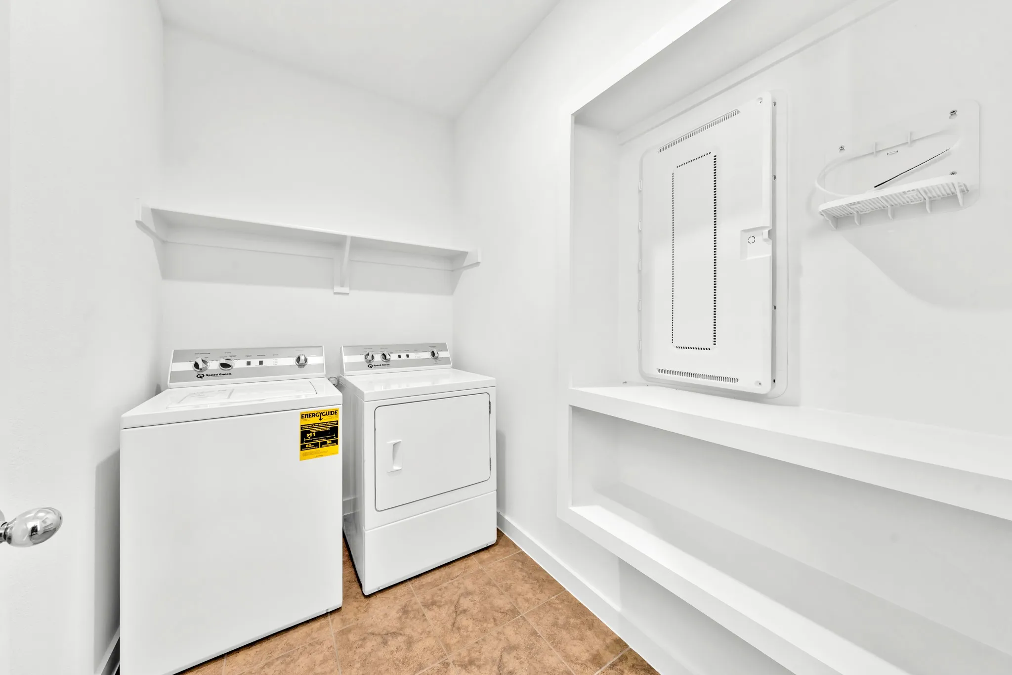Laundry area with a top-load washer, front-load dryer, and two wall-mounted shelves