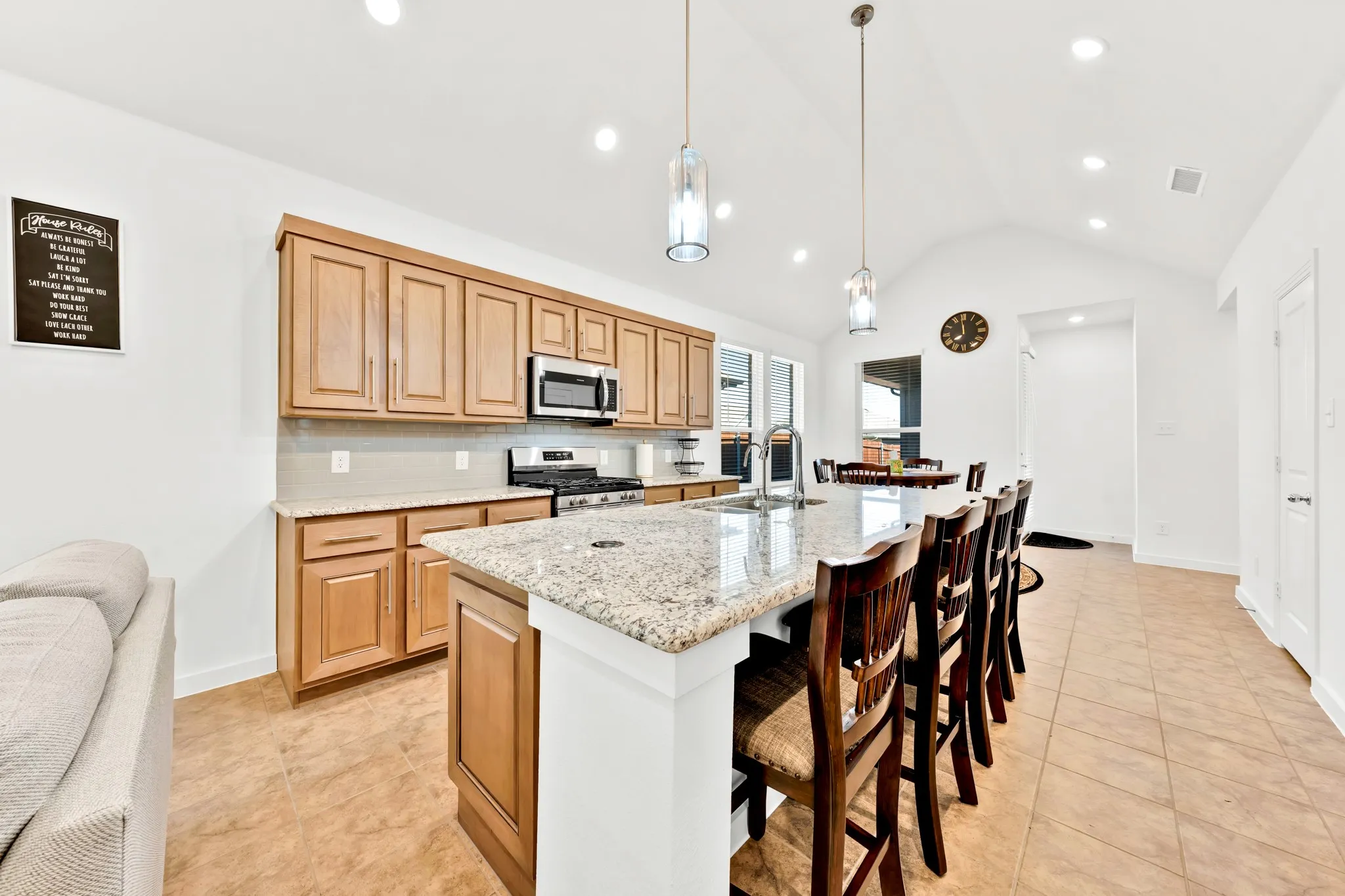 Kitchen featuring light wood cabinetry, a large center island with a light-toned countertop, stainless steel appliances, and recessed lighting