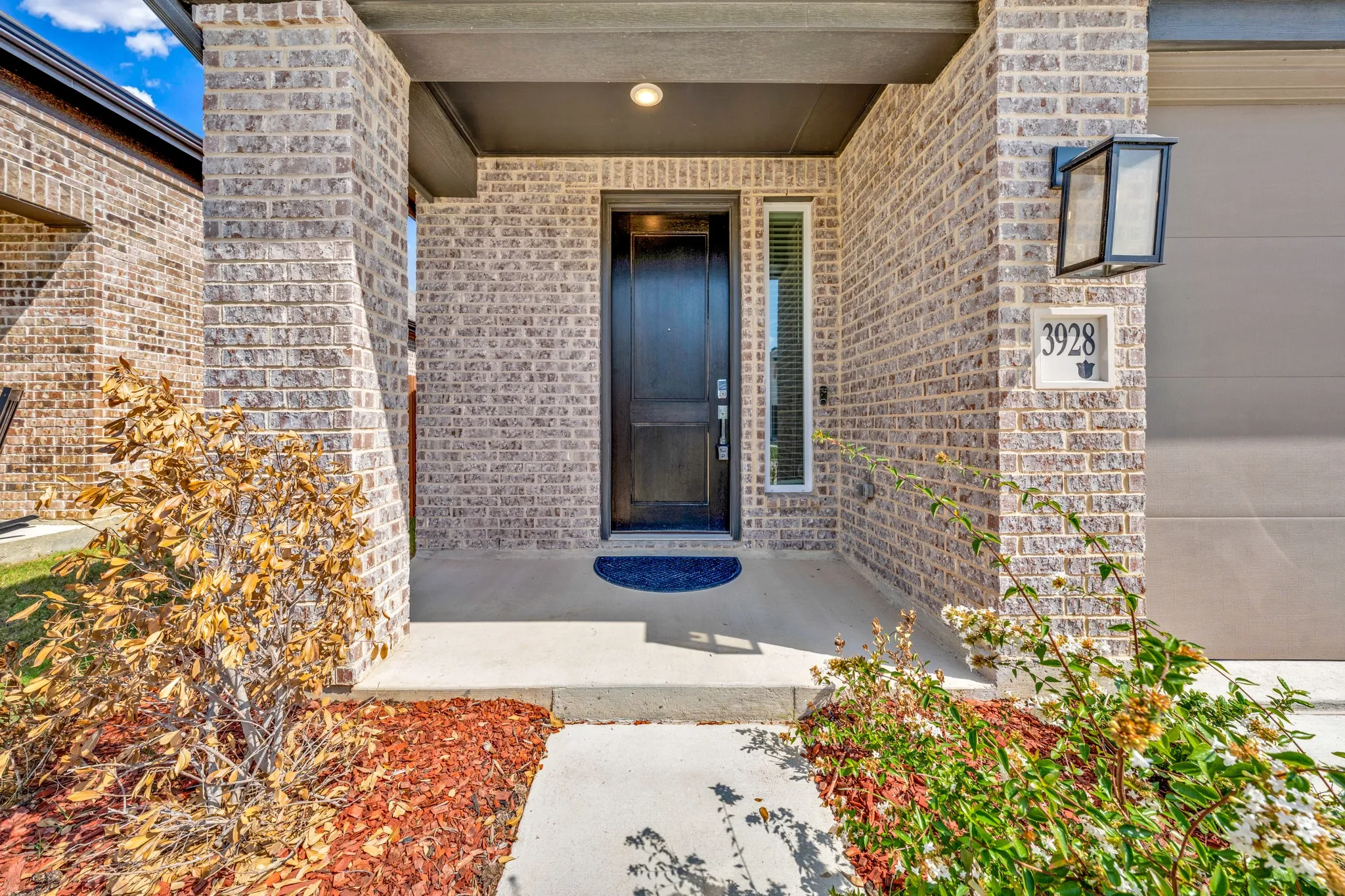 Brick facade with dark trim, covered porch, and a dark front entry door
