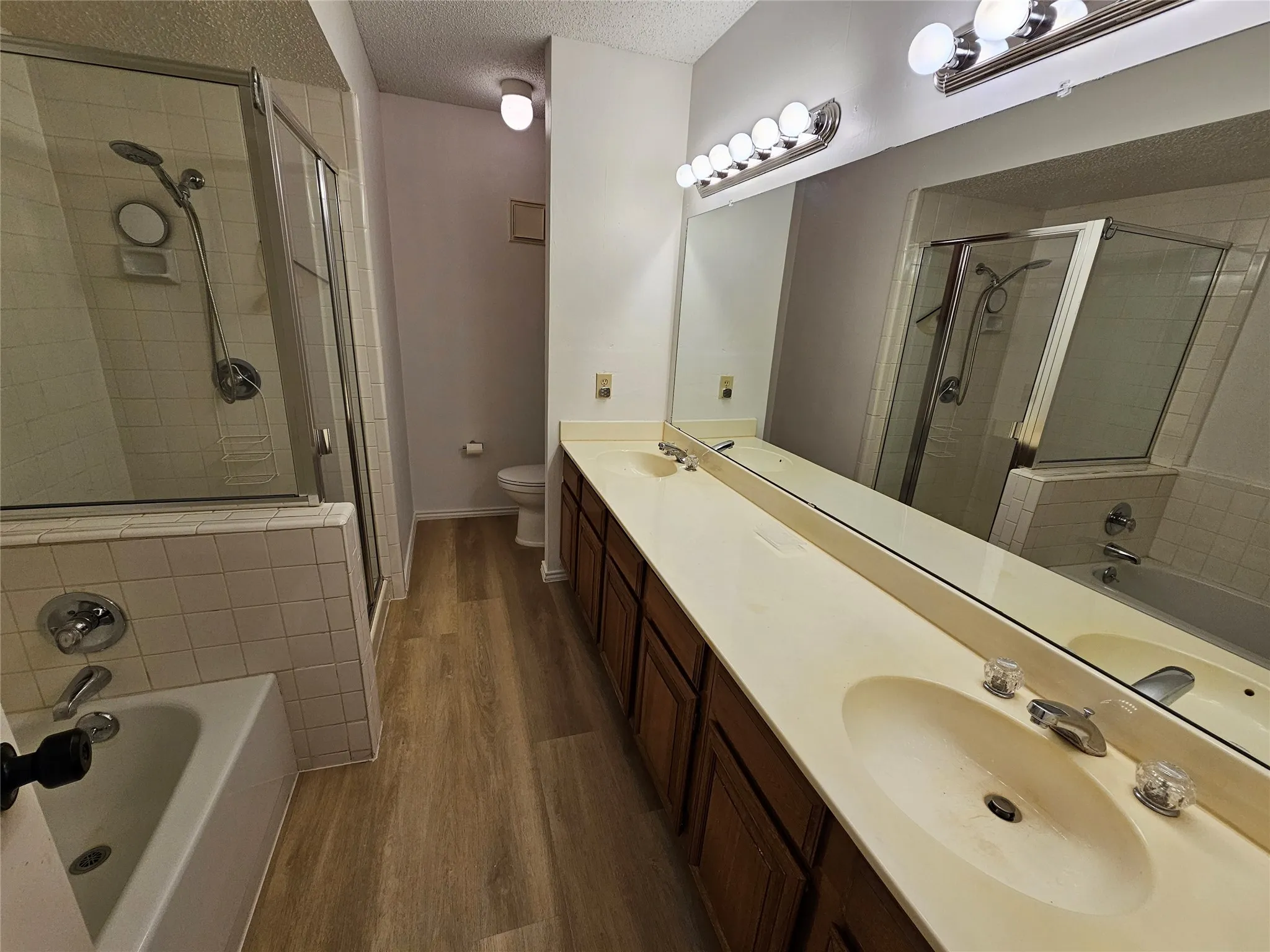 Primary bathroom featuring shower with separate bathtub and double sink vanity