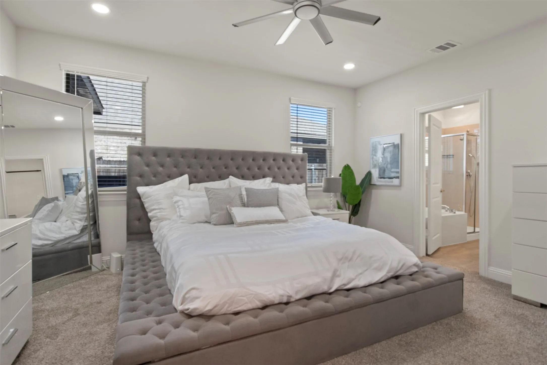 Light-toned wall finishes, recessed lighting, ceiling fan, carpeted flooring, and a connected bathroom featuring a shower and separate bathtub